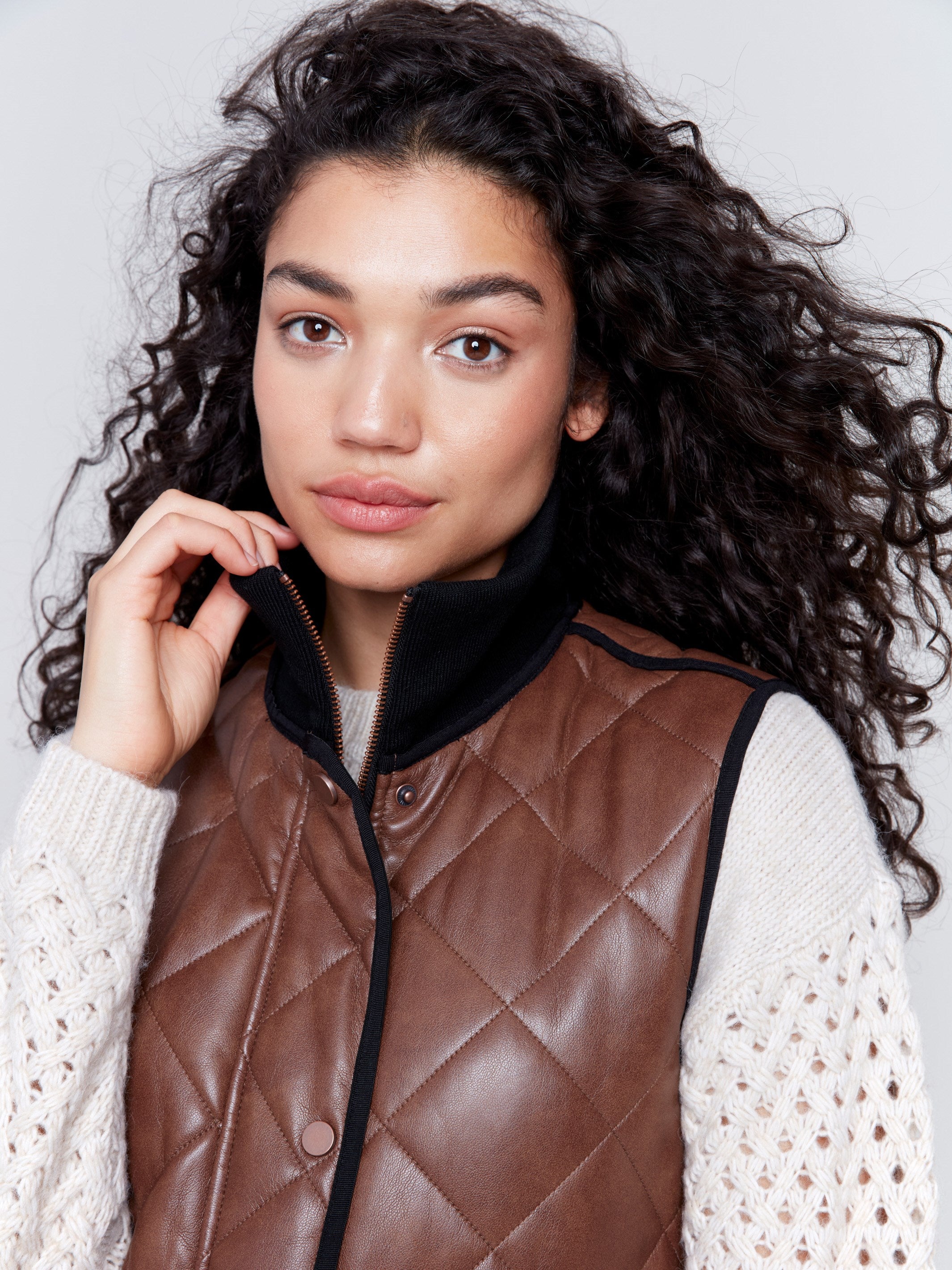 Brown faux leather vest with quilted design, featuring a front zipper closure and side welt pockets, by Charlie B.