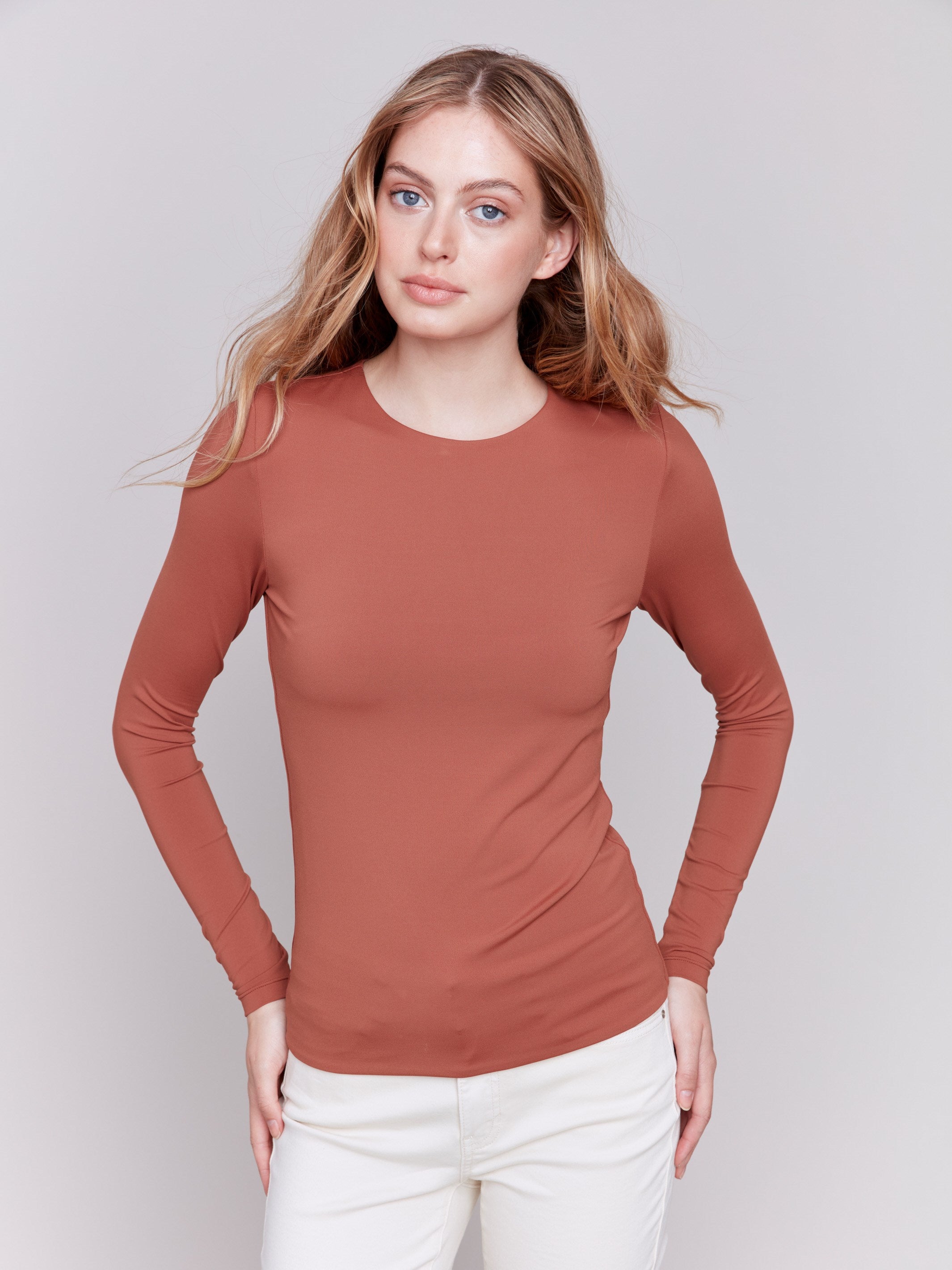 Terracotta long-sleeve top with crew neckline, featuring a fitted silhouette by Charlie B.