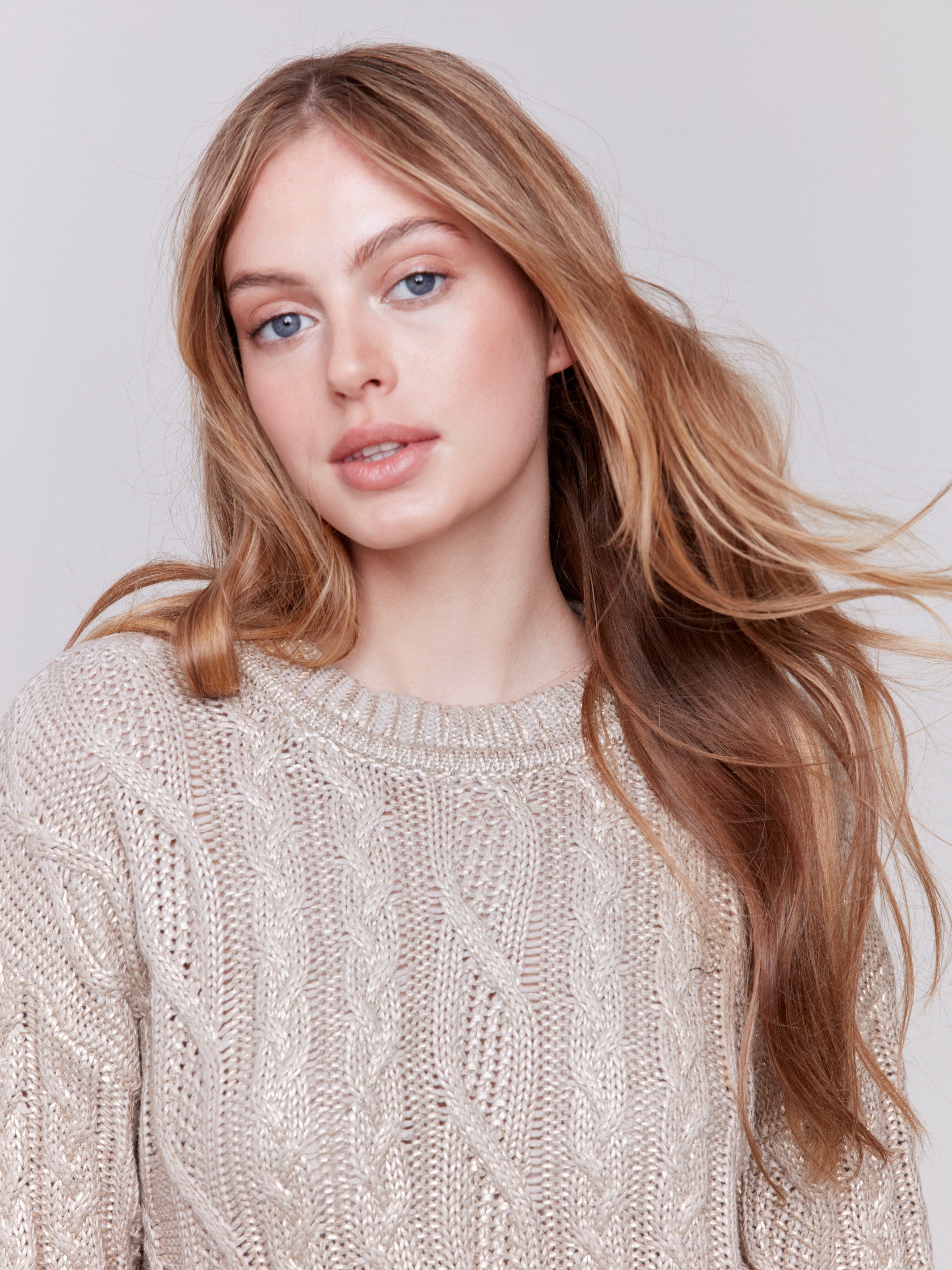 Champagne colored metallic cable knit sweater with a crew neck and long sleeves by Charlie B.