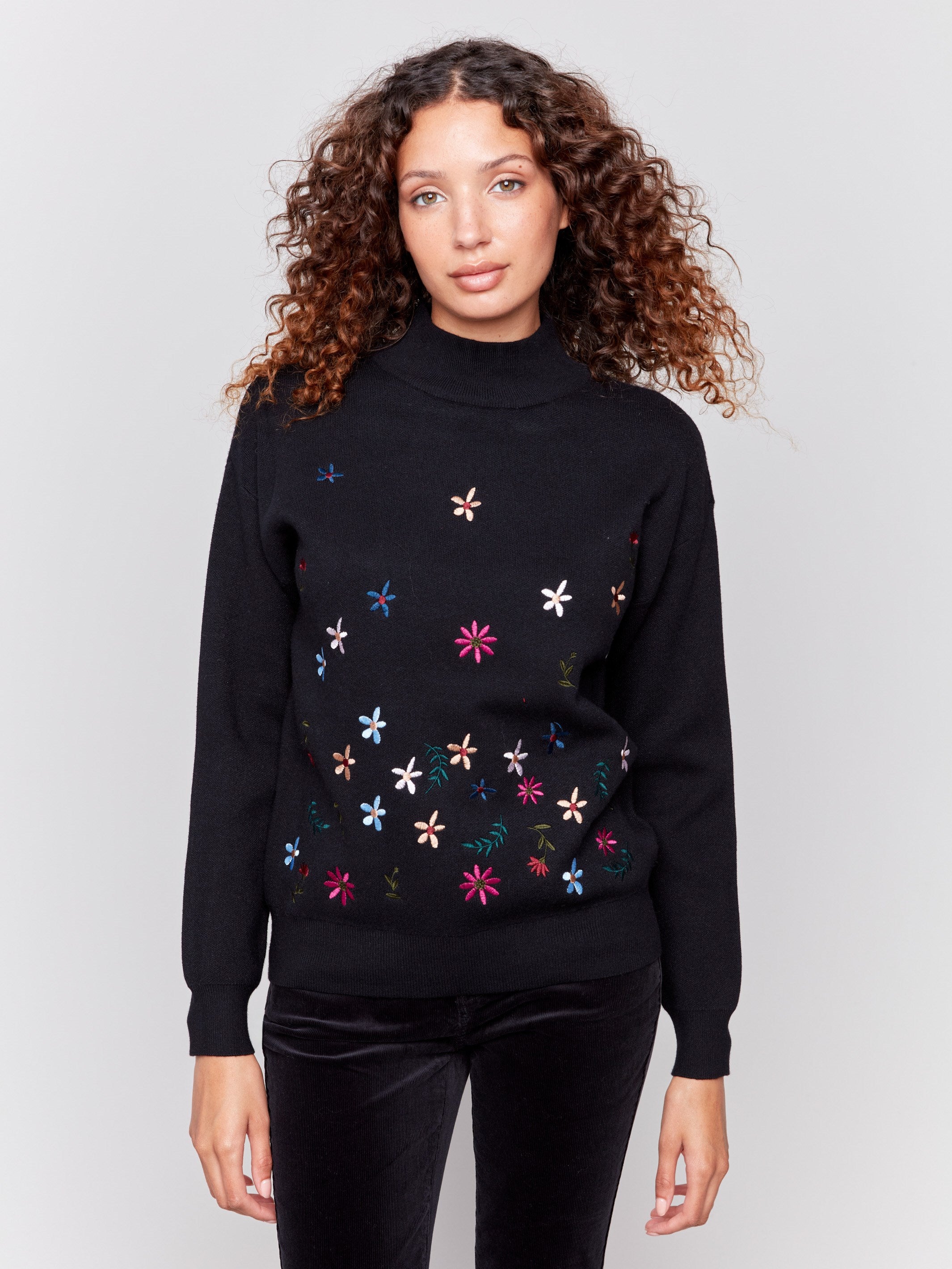 Black long-sleeve mock neck sweater with colorful floral embroidery by Charlie B.