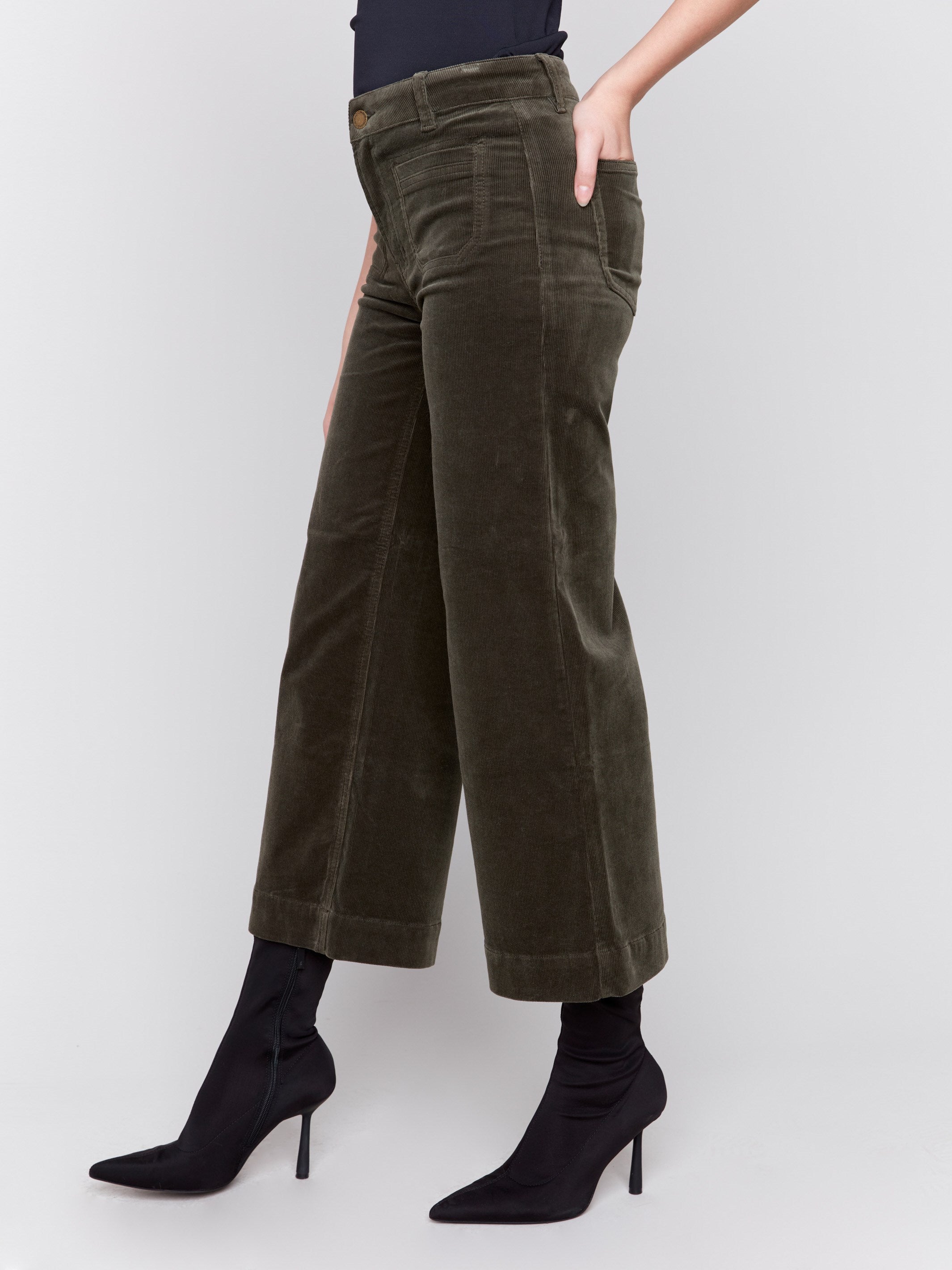 Green corduroy flare pants with front and back patch pockets, a regular rise, and cropped design by Charlie B.