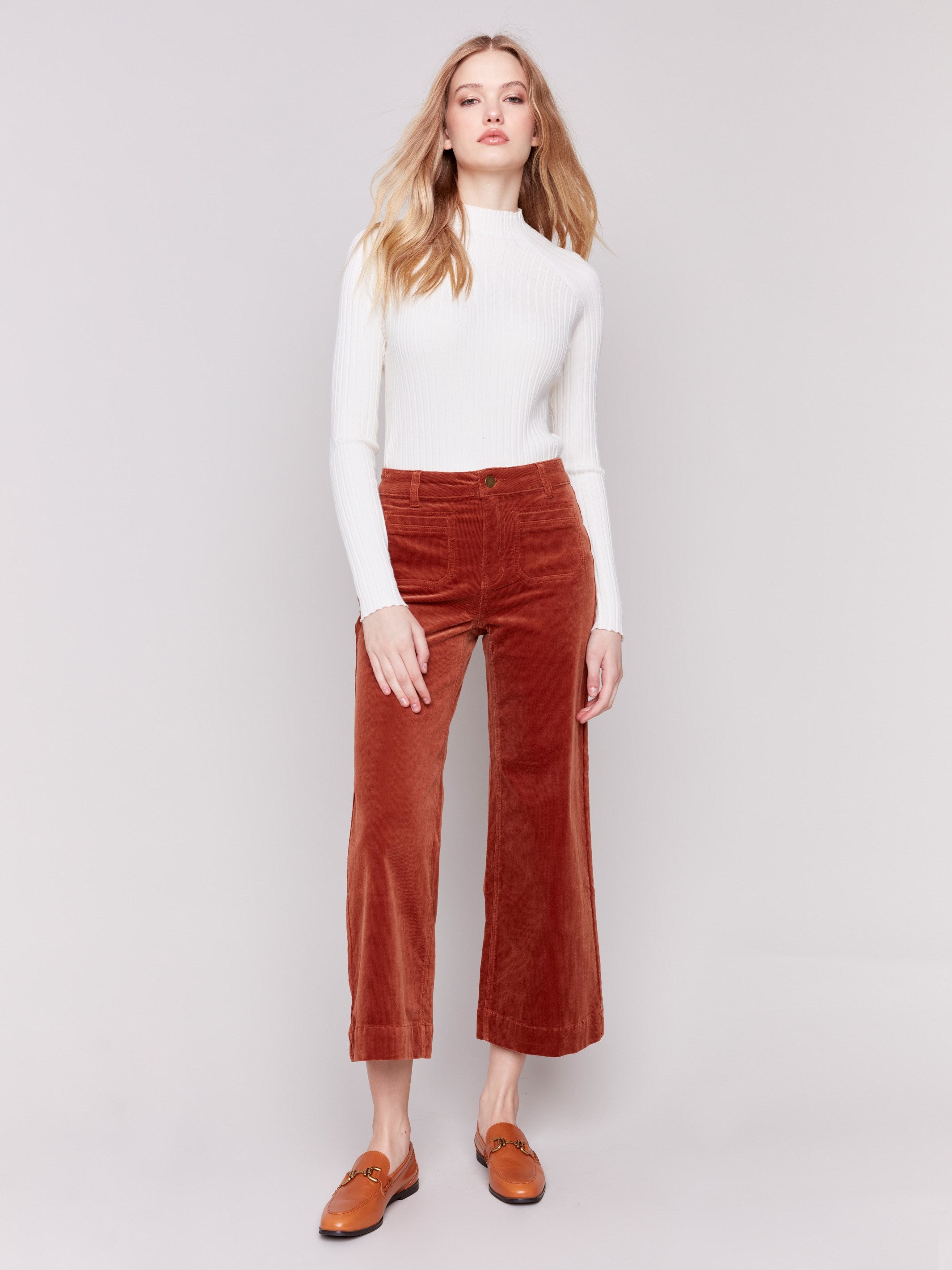 Terracotta orange corduroy flare pants with front and back patch pockets, a regular rise, and cropped design by Charlie B.