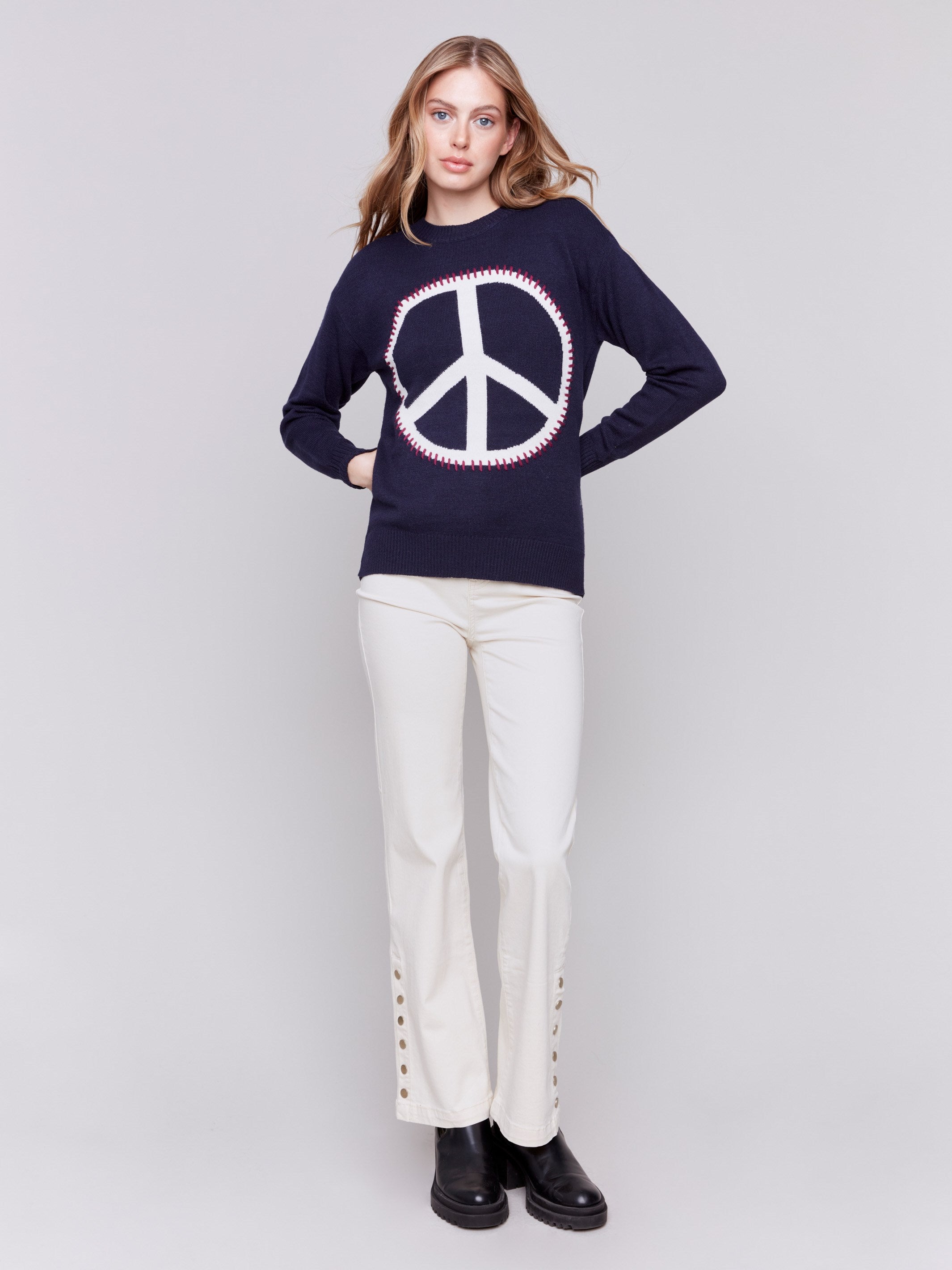 Navy blue sweater featuring a large peace sign graphic on the front with blanket stitch detailing, long sleeves, and crew neckline by Charlie B.