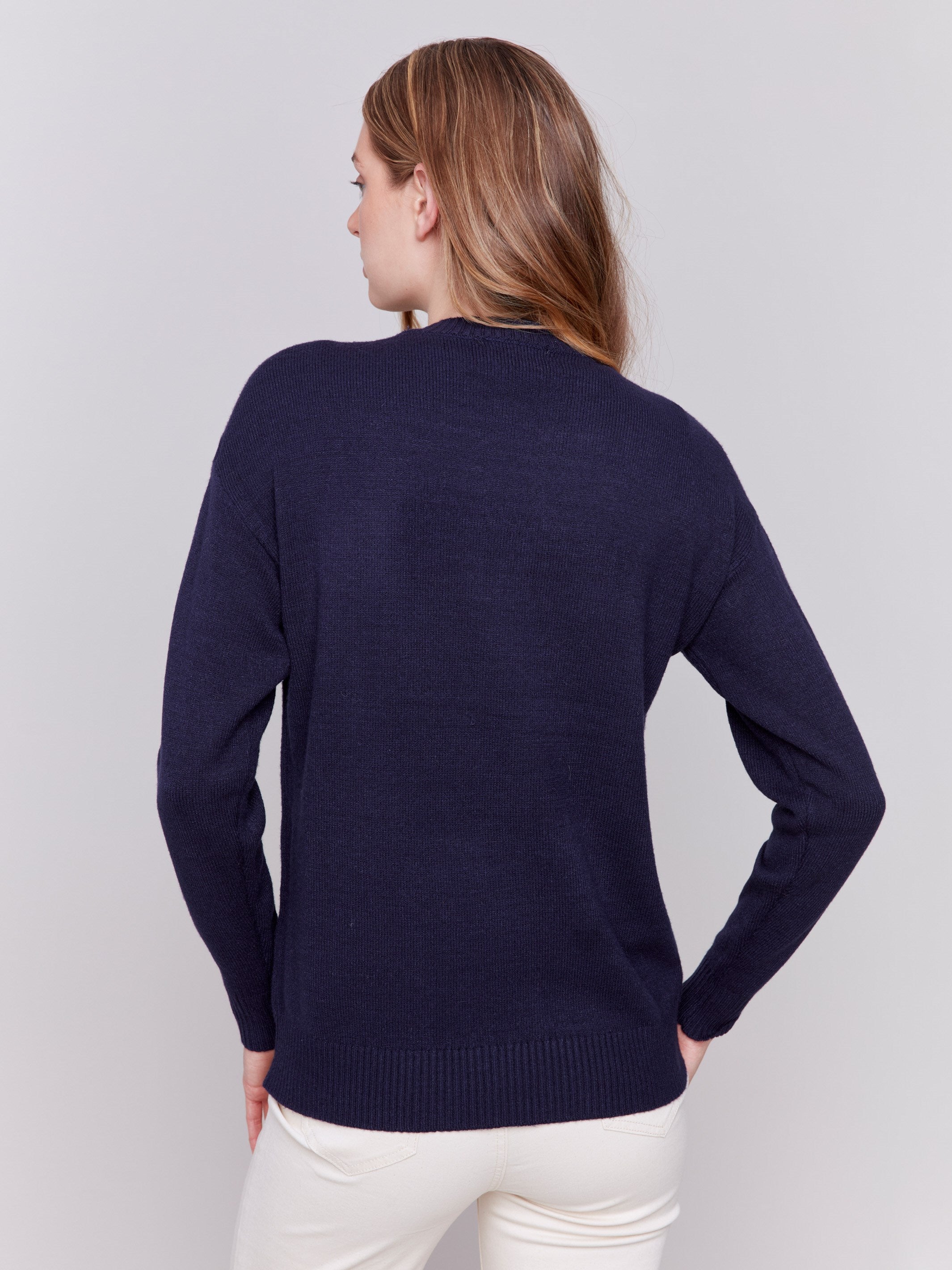 Navy blue sweater featuring a large peace sign graphic on the front with blanket stitch detailing, long sleeves, and crew neckline by Charlie B.