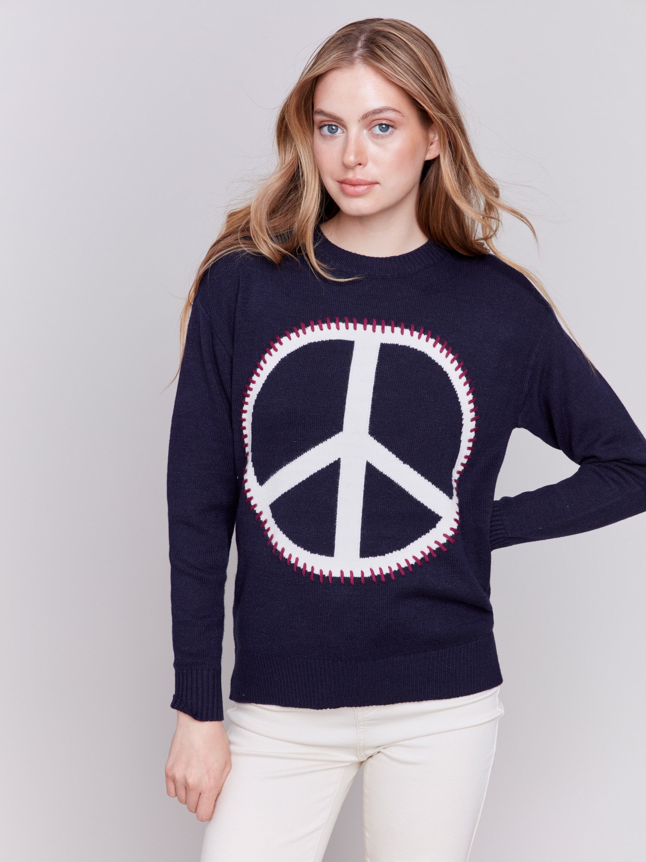 Navy blue sweater featuring a large peace sign graphic on the front with blanket stitch detailing, long sleeves, and crew neckline by Charlie B.