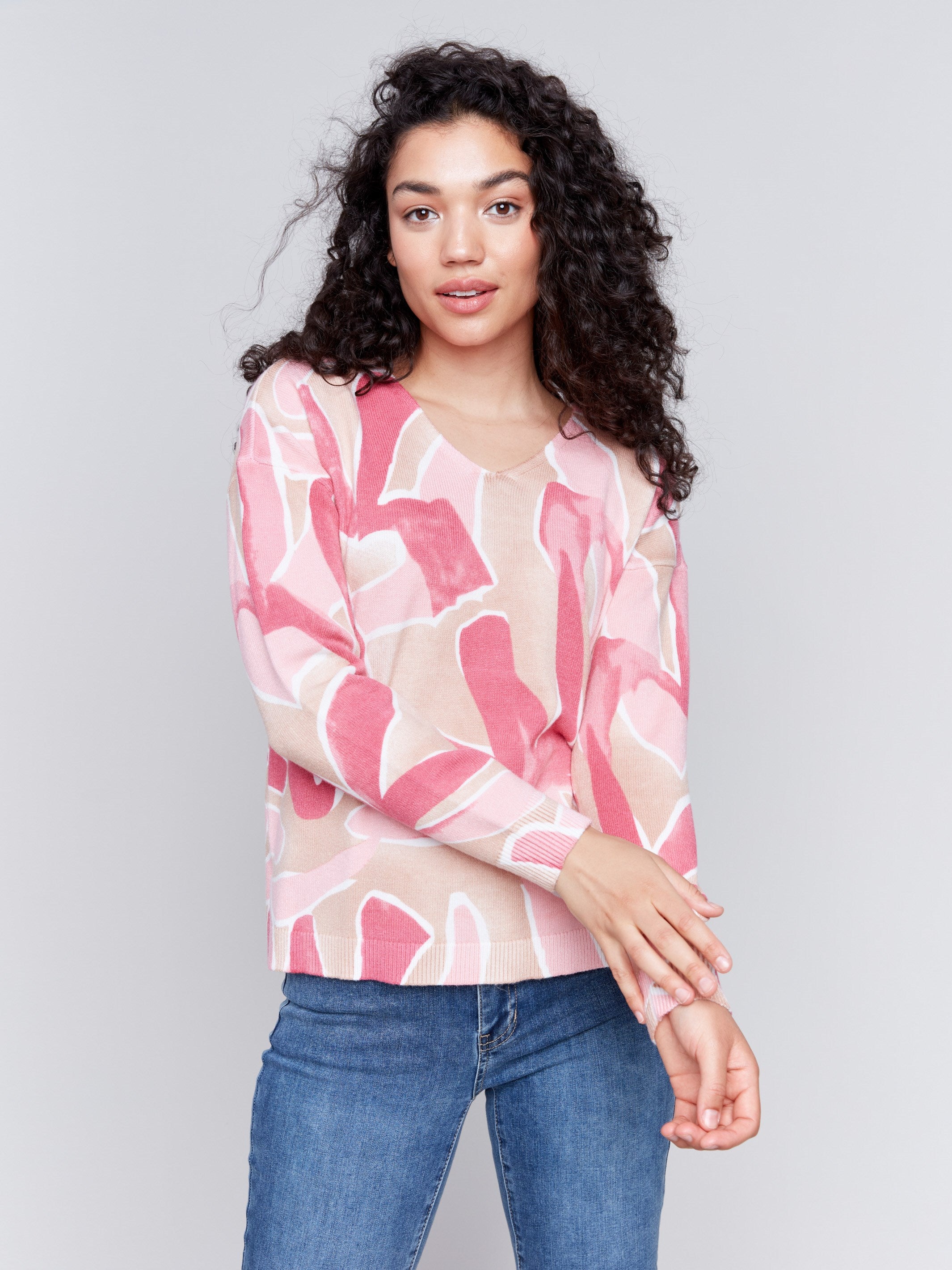 Raspberry pink V-neck sweater with an abstract print and drop shoulders by Charlie B.