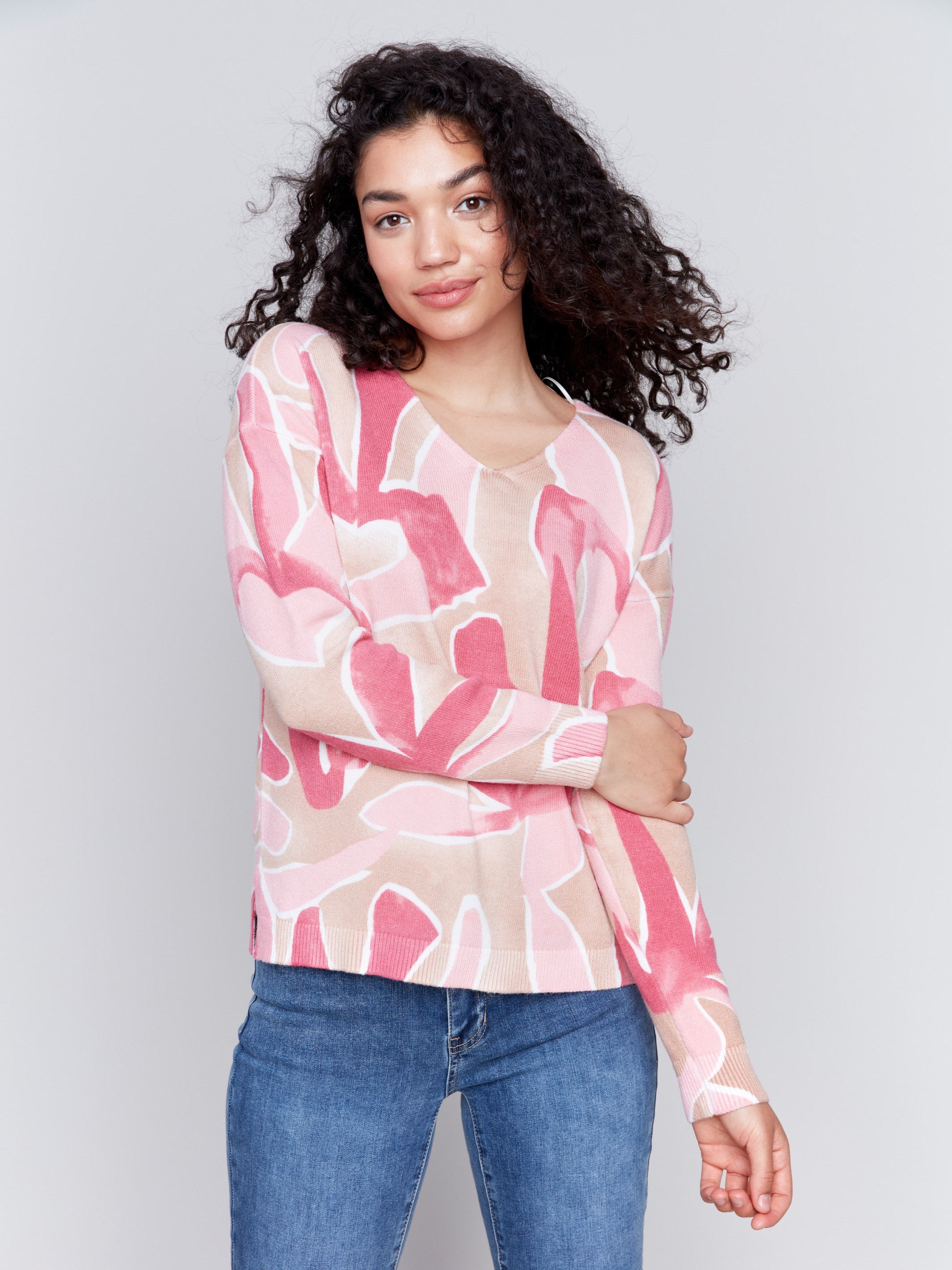 Raspberry pink V-neck sweater with an abstract print and drop shoulders by Charlie B.