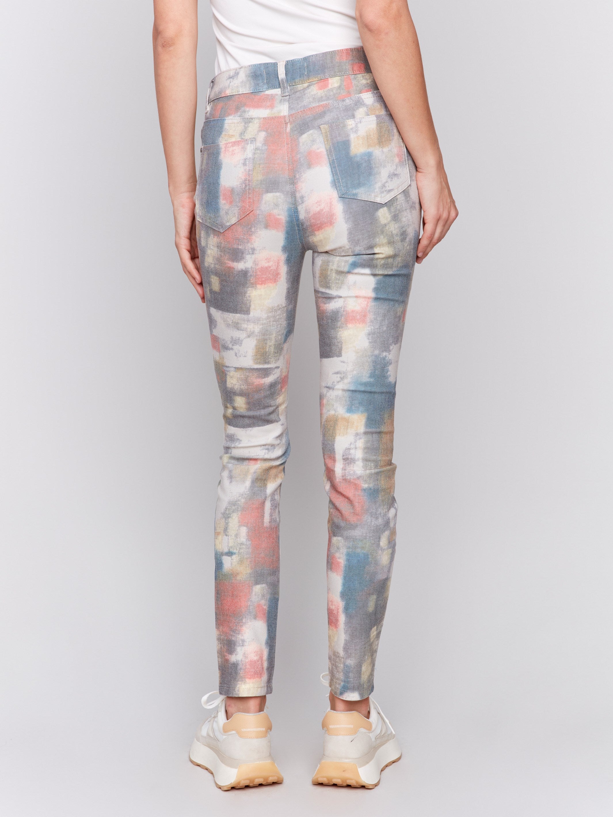 Women's slim-fit pants in a vibrant abstract print. These stretch twill pants feature a regular rise, five-pocket design, and a comfortable skinny leg fit by Charlie B.