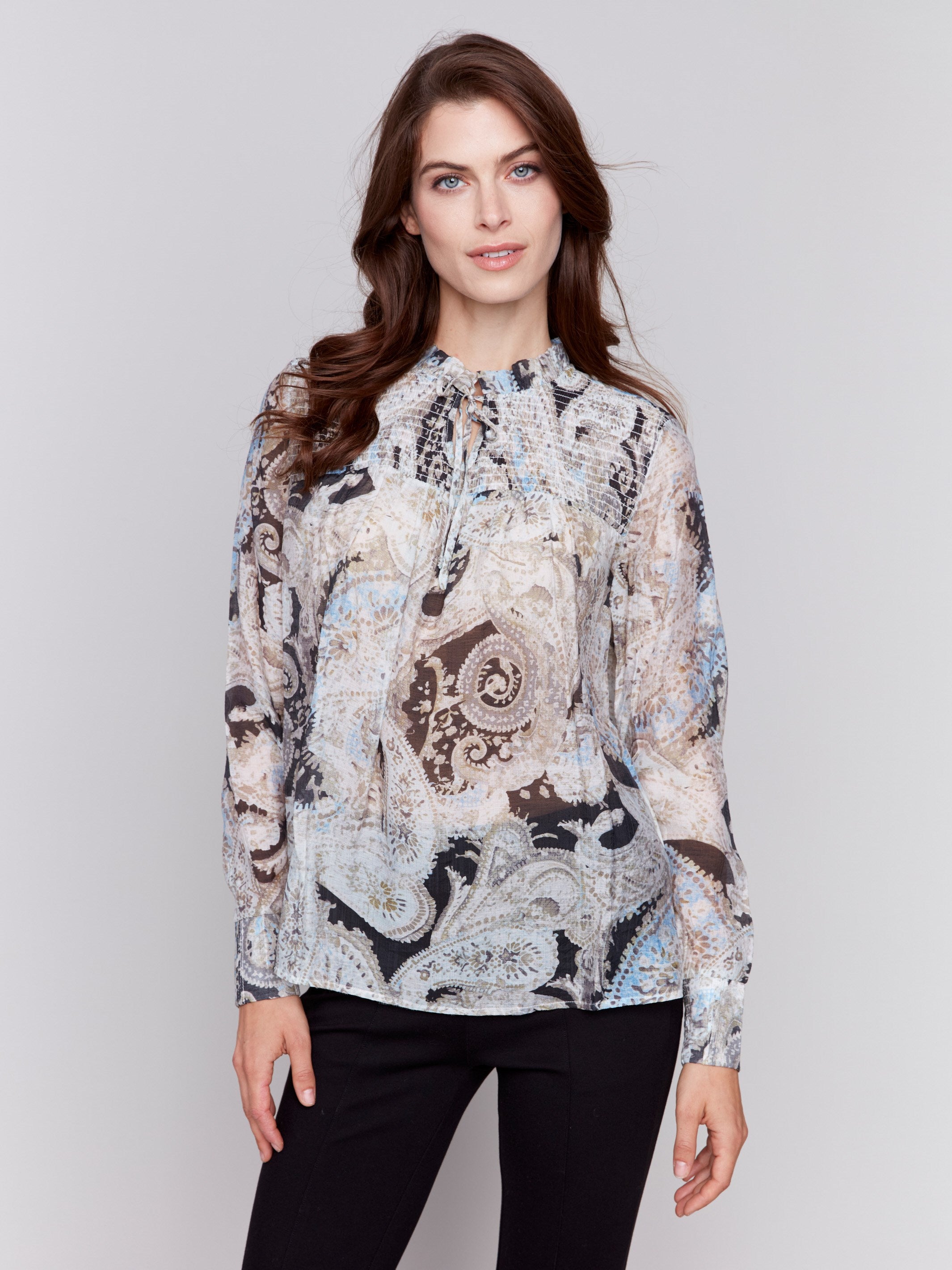 Elegant paisley printed voile blouse in aqua tones, featuring a smocked collar and tie-up neckline by Charlie B.