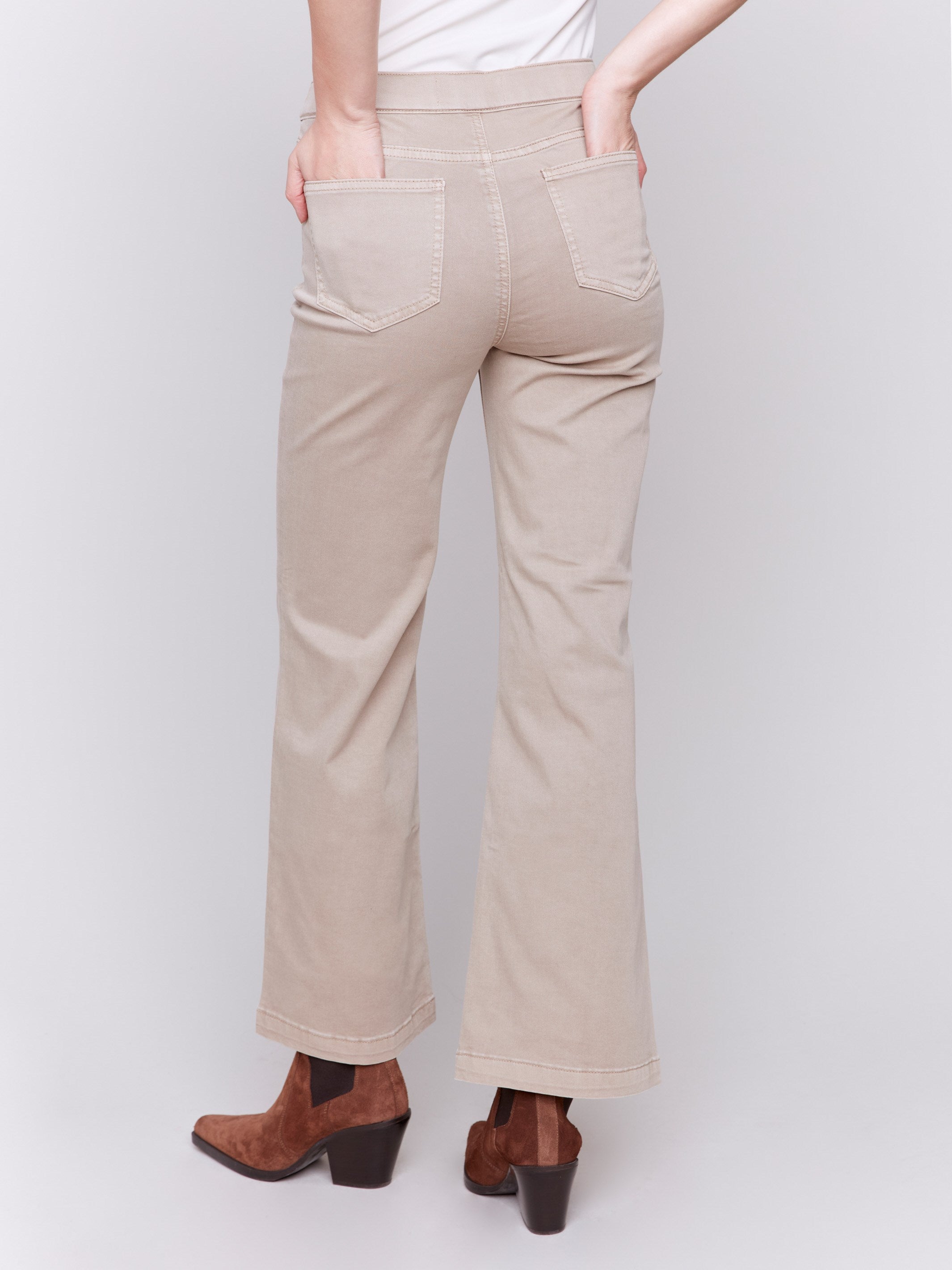 Beige pull-on flare twill pants with front buttons and a flare leg design by Charlie B.