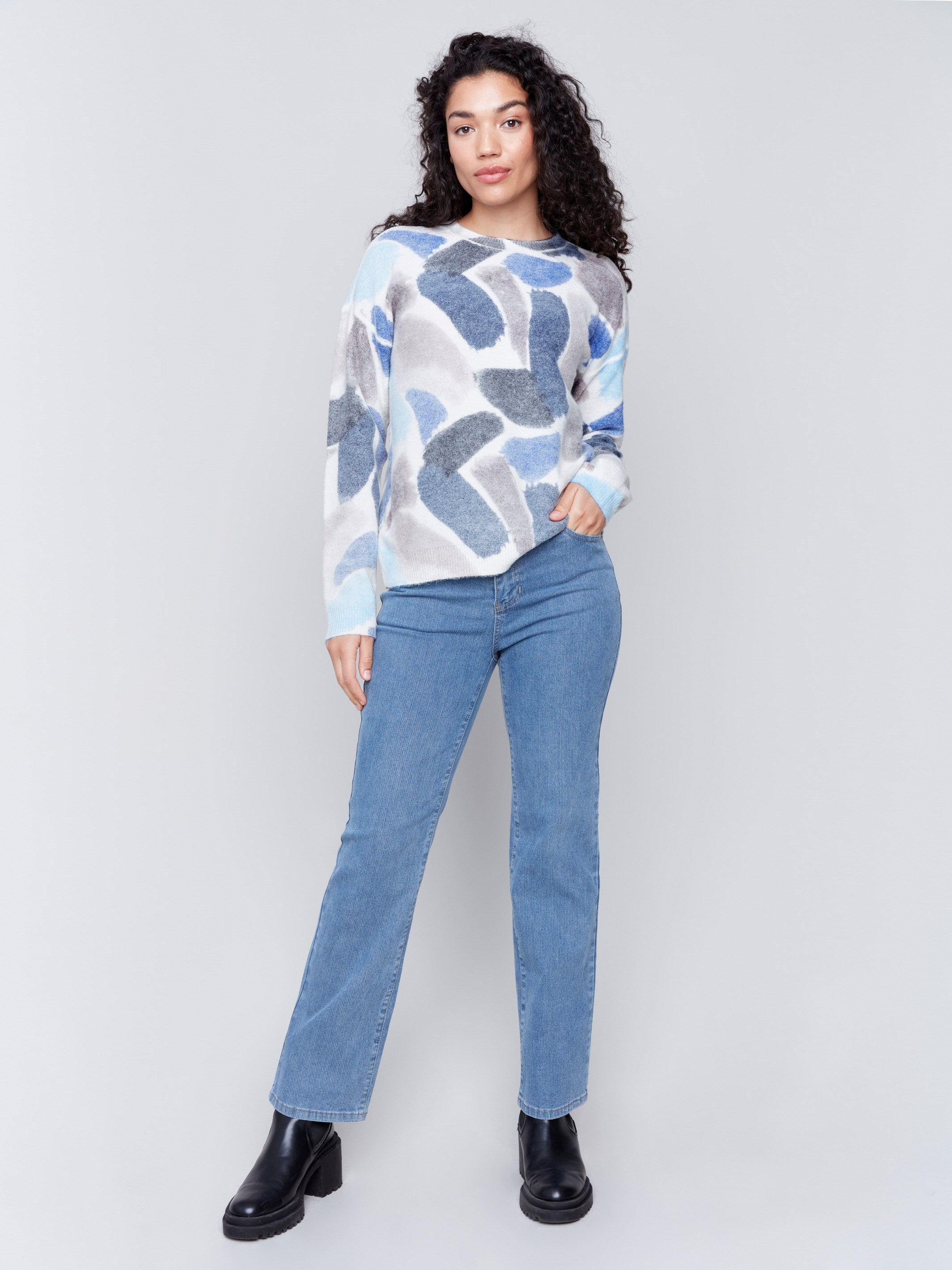 Woman wearing a reversible sweater with sapphire blue abstract prints and a crew neckline by Charlie B.