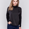 Black satin-knit top with a mock neck and front seam detail, featuring long sleeves and ribbed cuffs by Charlie B.