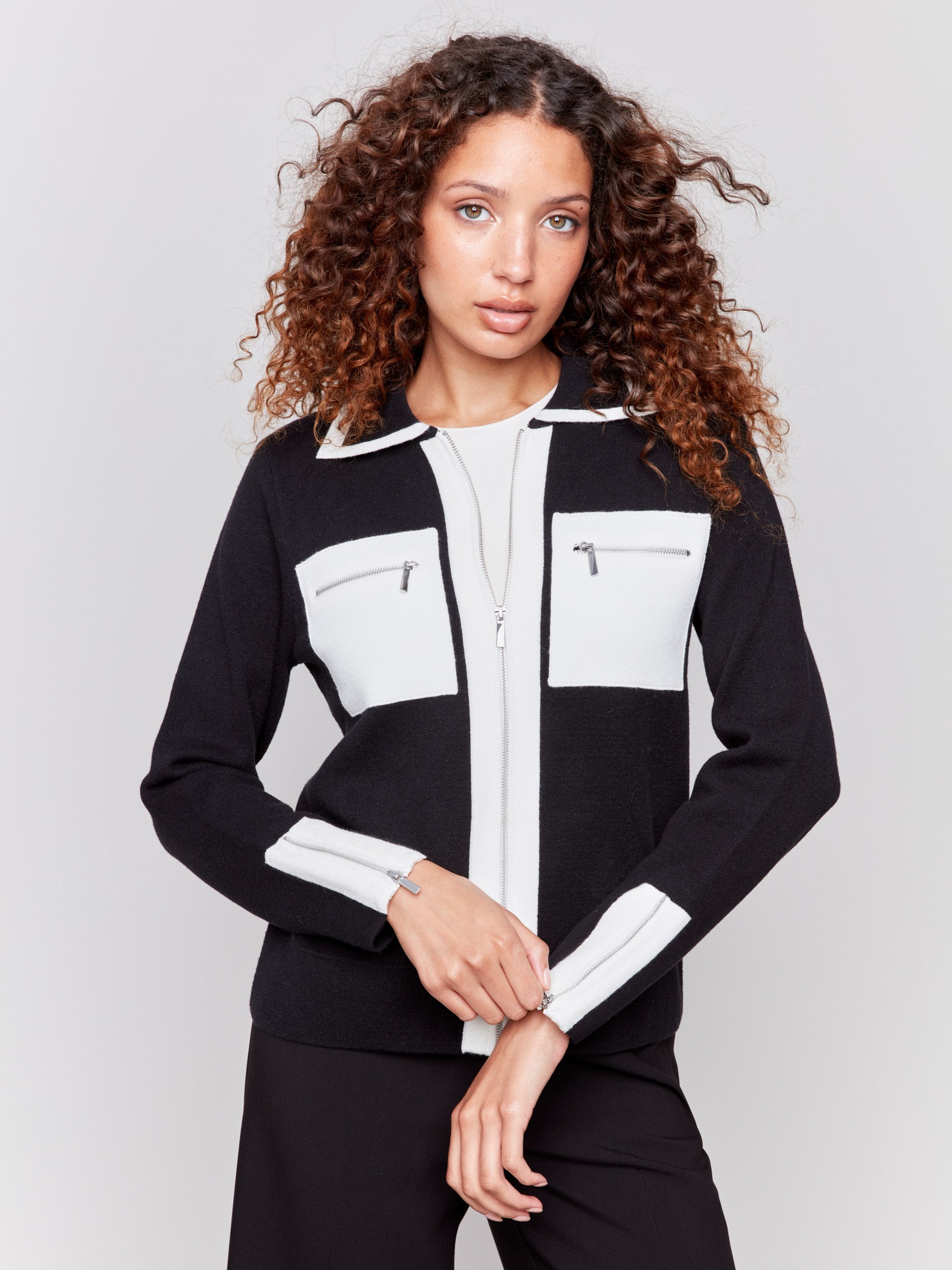 Black and white short knit jacket with a front zipper closure and front patch pockets featuring stylish design by Charlie B.