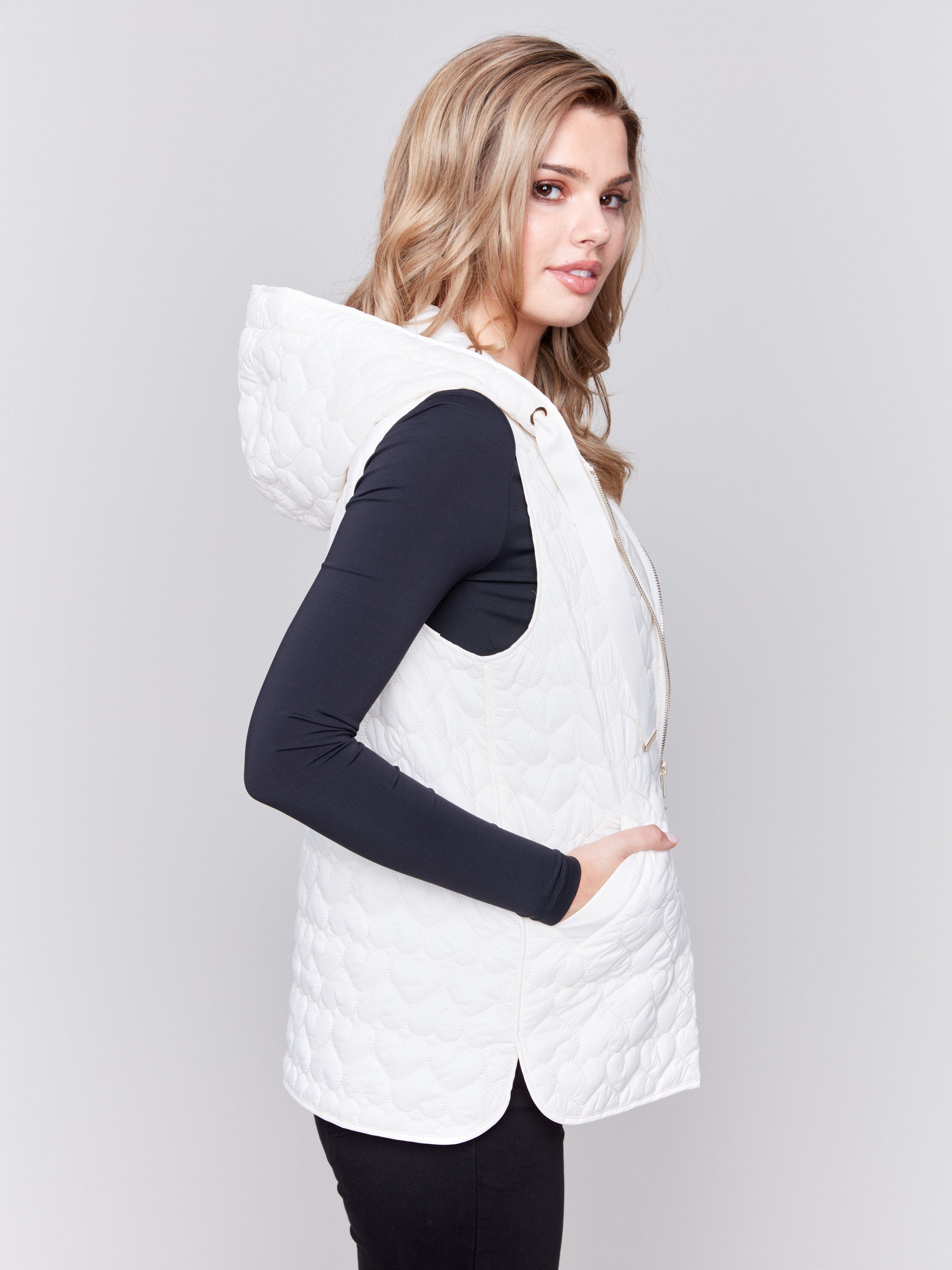 Ecru white short quilted puffer vest with a hood, featuring a mini heart pattern and front pockets by Charlie B.