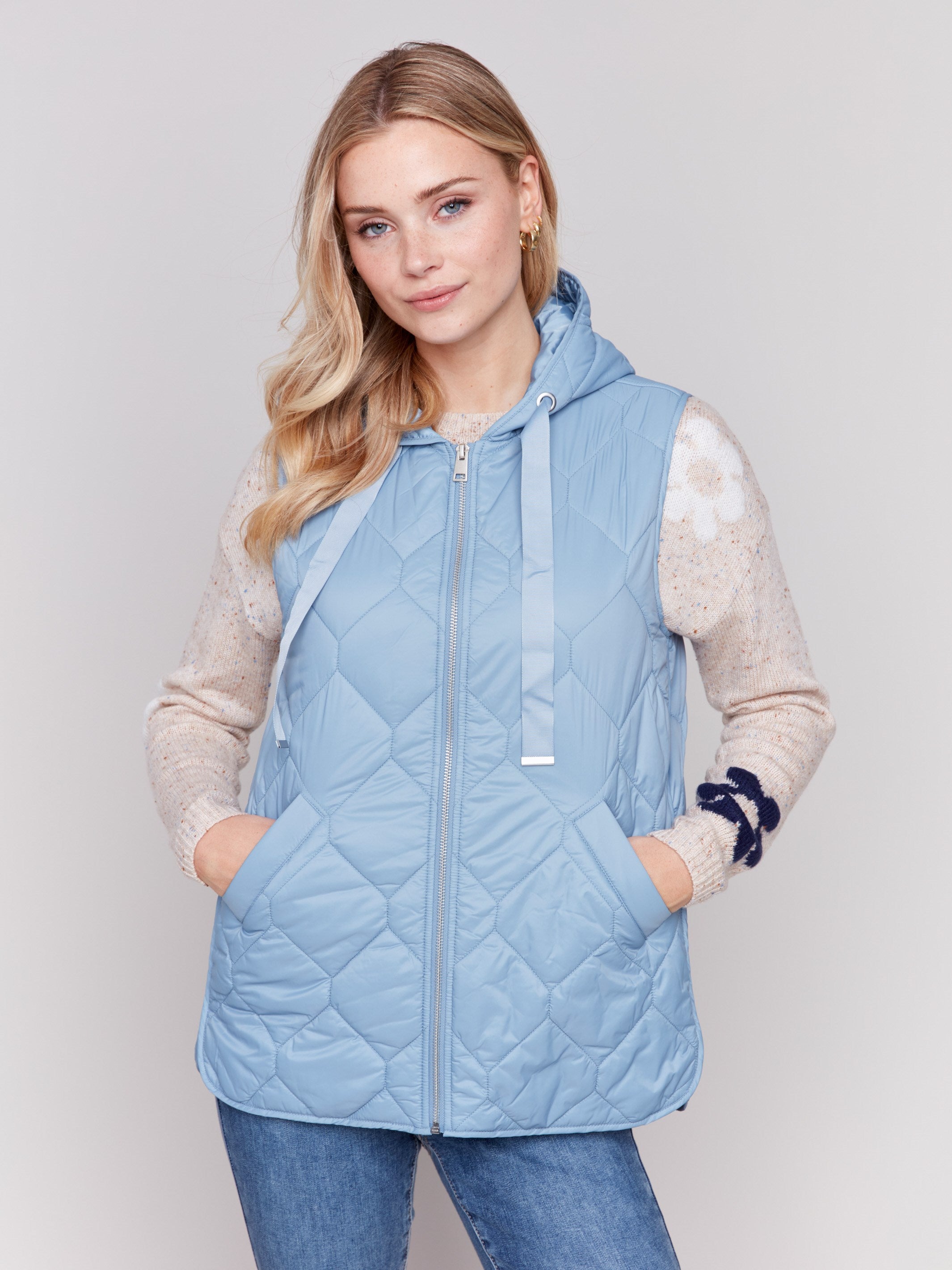 Light blue short quilted puffer vest with hood, featuring a zippered front and side pockets by Charlie B.