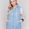 Light blue short quilted puffer vest with hood, featuring a zippered front and side pockets by Charlie B.