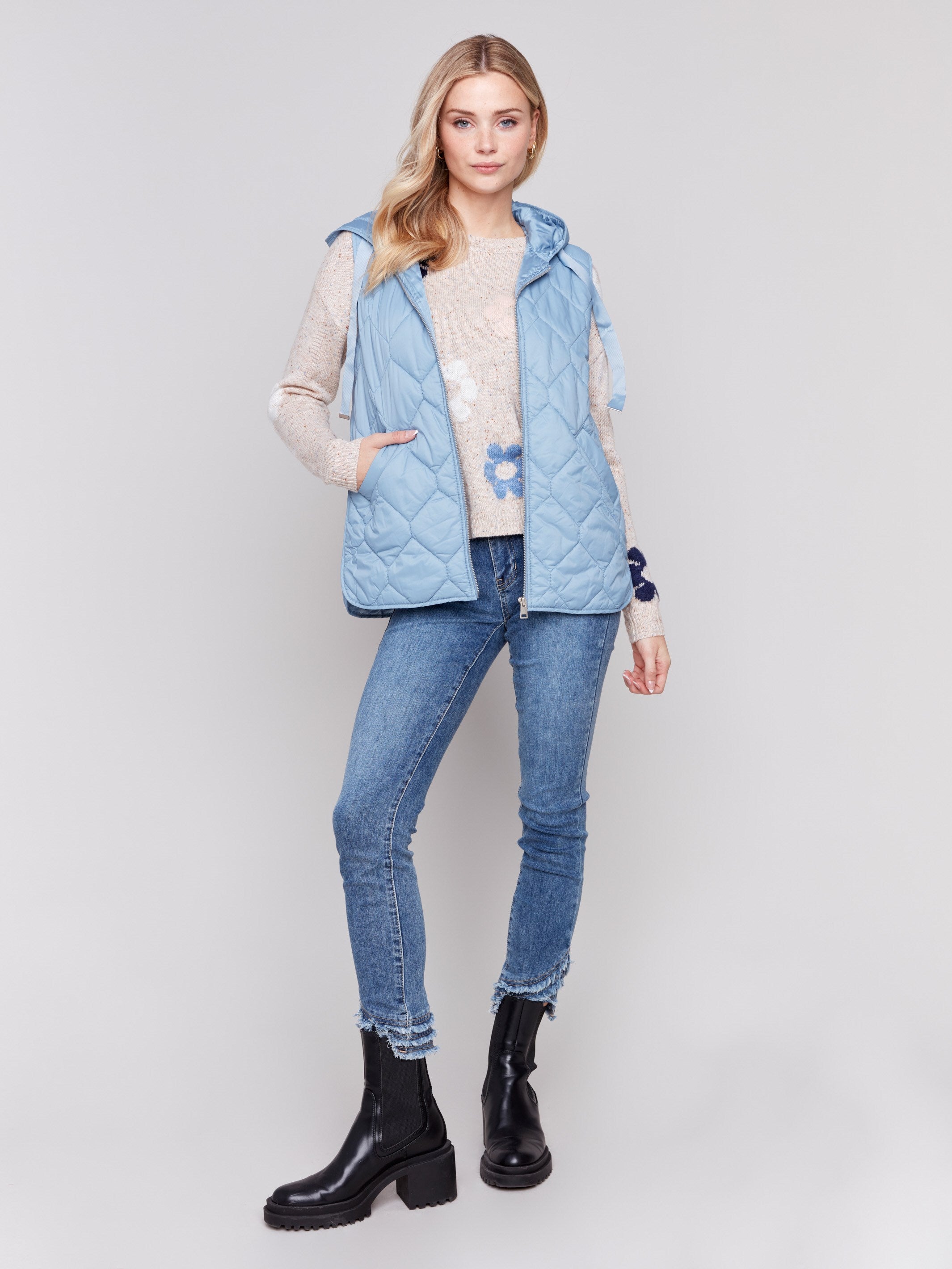 Light blue short quilted puffer vest with hood, featuring a zippered front and side pockets by Charlie B.