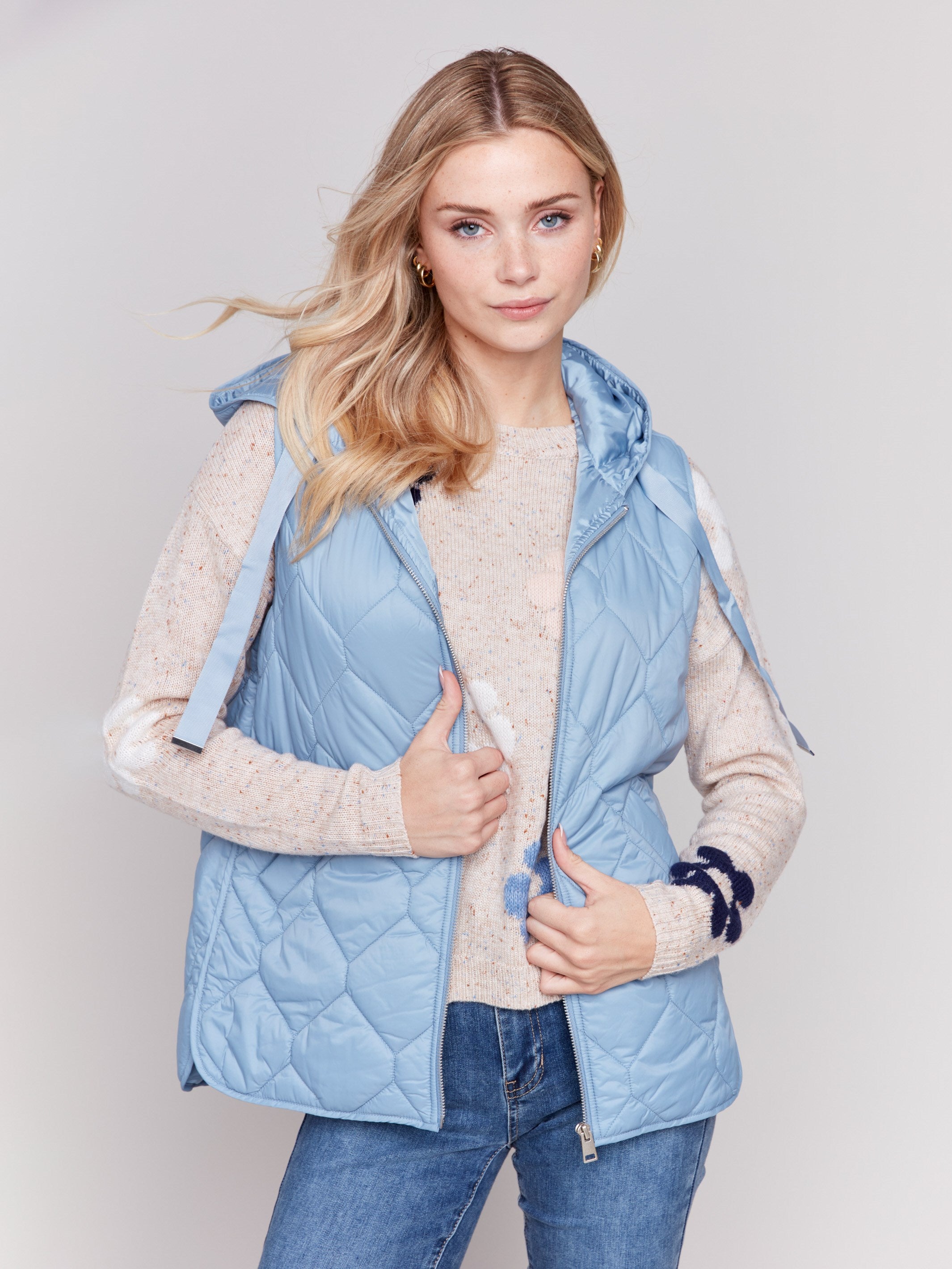 Light blue short quilted puffer vest with hood, featuring a zippered front and side pockets by Charlie B.