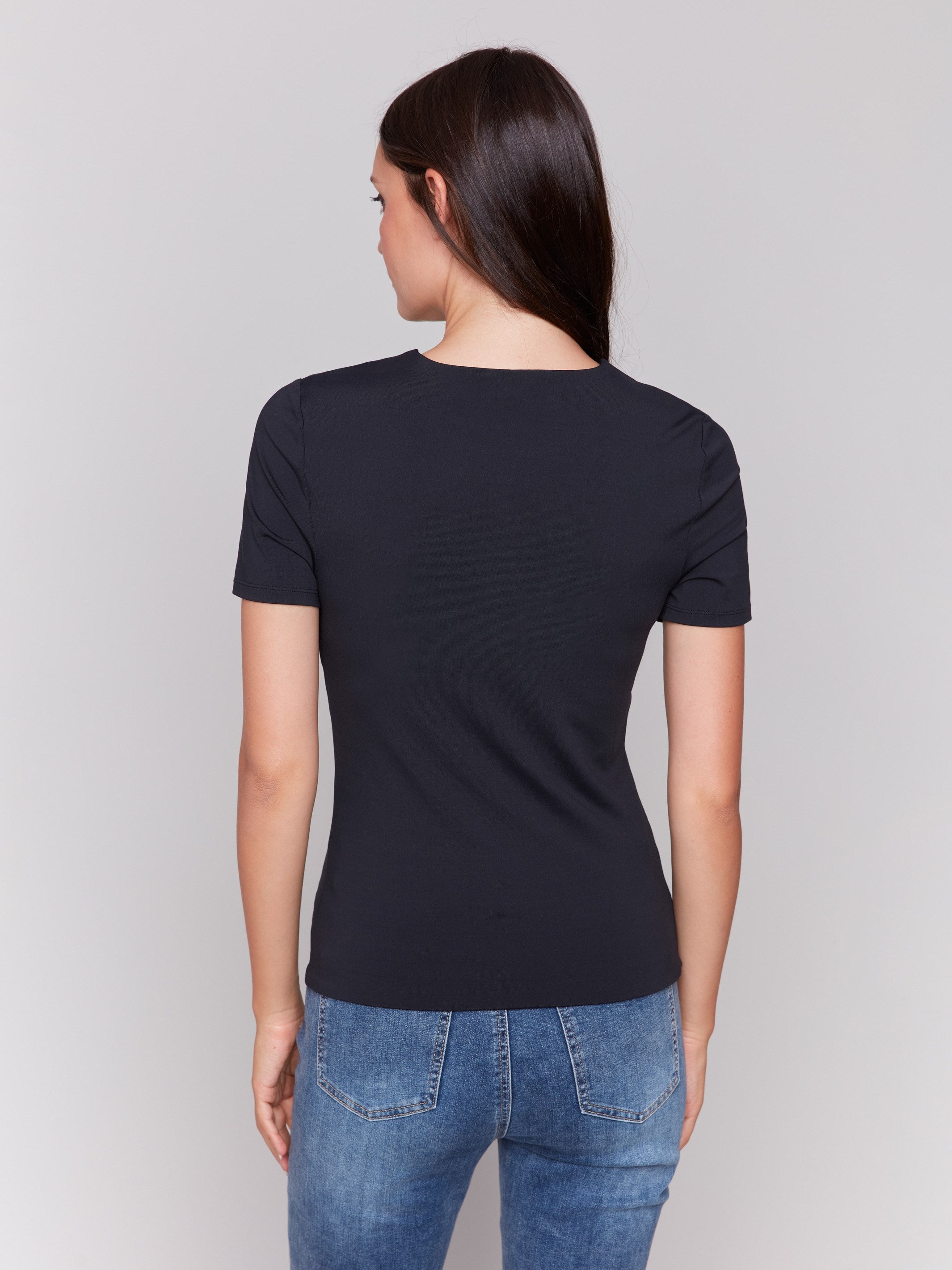 Black short-sleeved super stretch top with a crew neckline, showcasing a slim fit design by Charlie B.