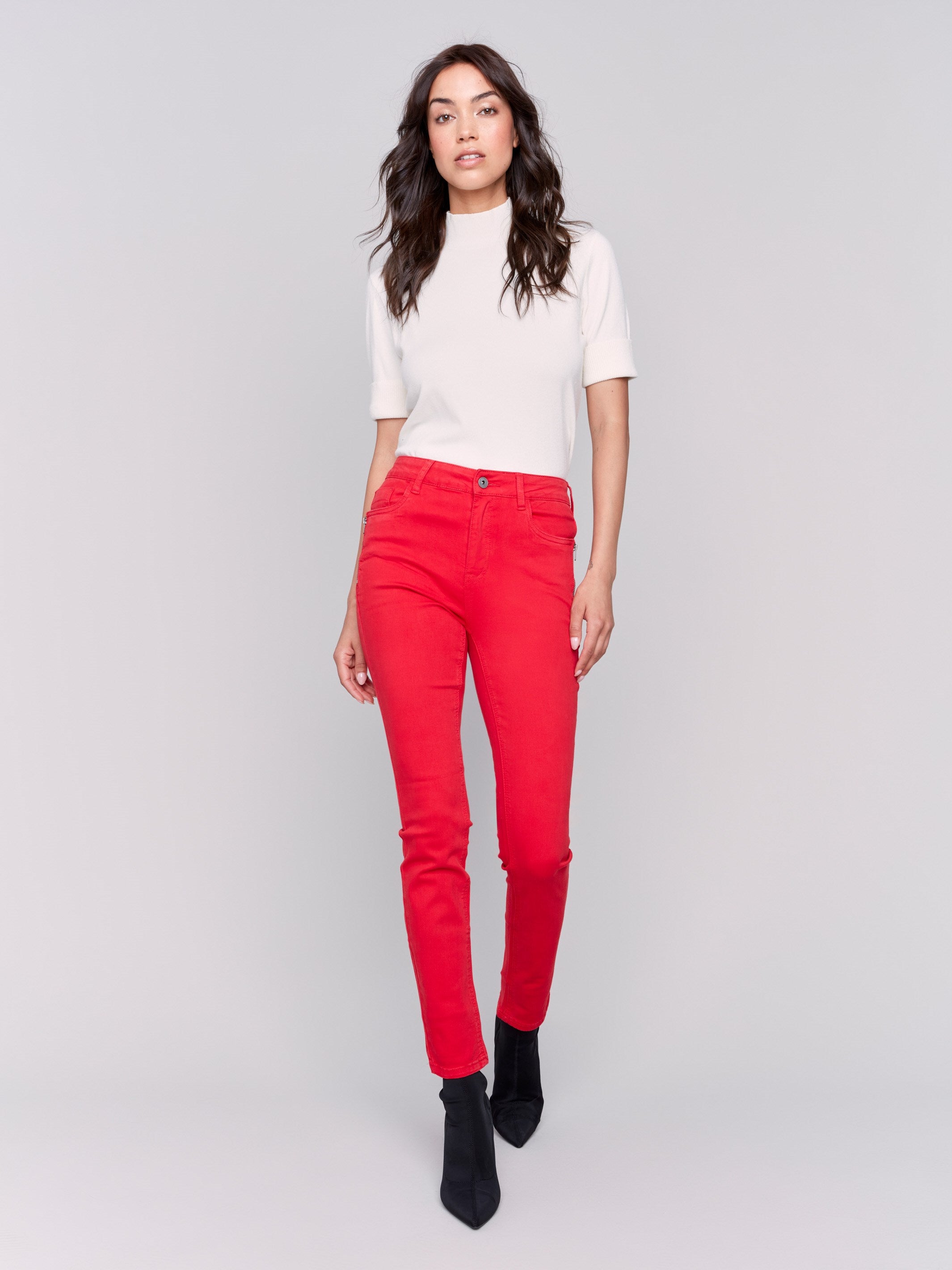 Cranberry red skinny twill pants with a mid-rise waist, skinny fit, and side zipper pocket details by Charlie B.