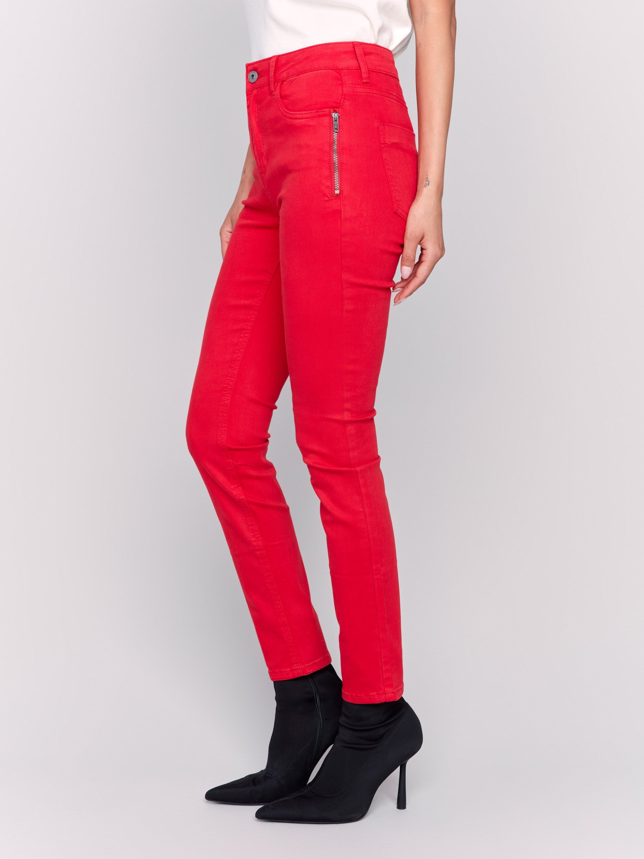 Cranberry red skinny twill pants with a mid-rise waist, skinny fit, and side zipper pocket details by Charlie B.