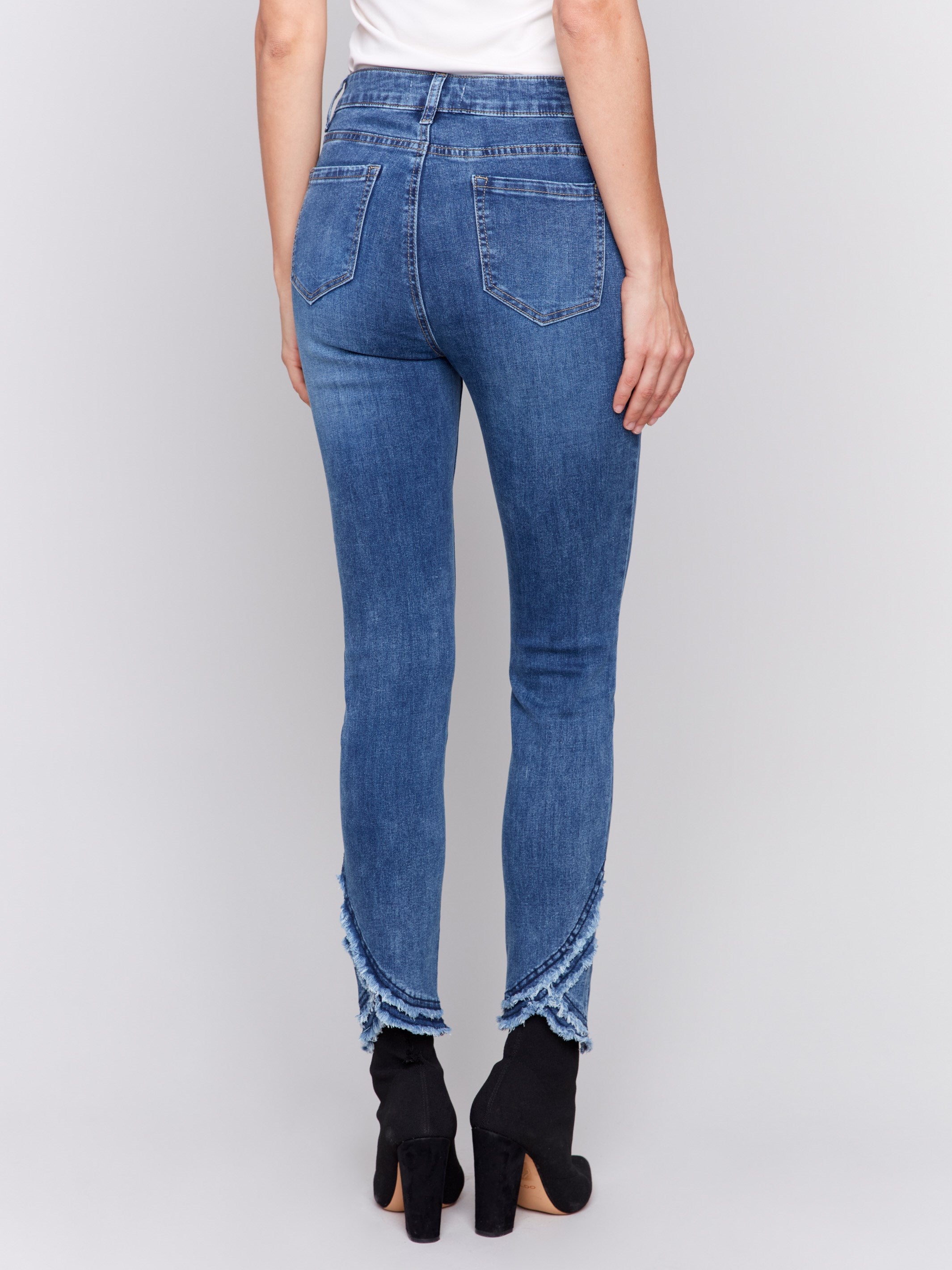 Medium blue slim fit jeans featuring a frayed two-layer tulip hem design, regular rise, and five-pocket style by Charlie B.