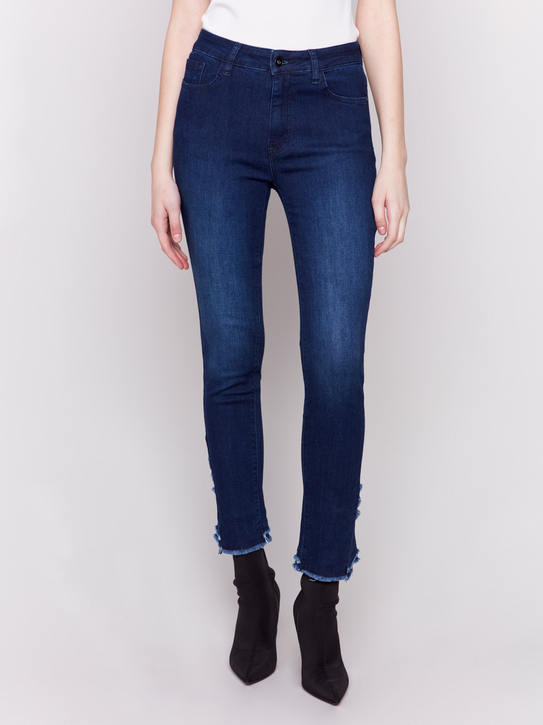 Dark blue slim fit jeans featuring a frayed two-layer tulip hem design, regular rise, and five-pocket style by Charlie B.