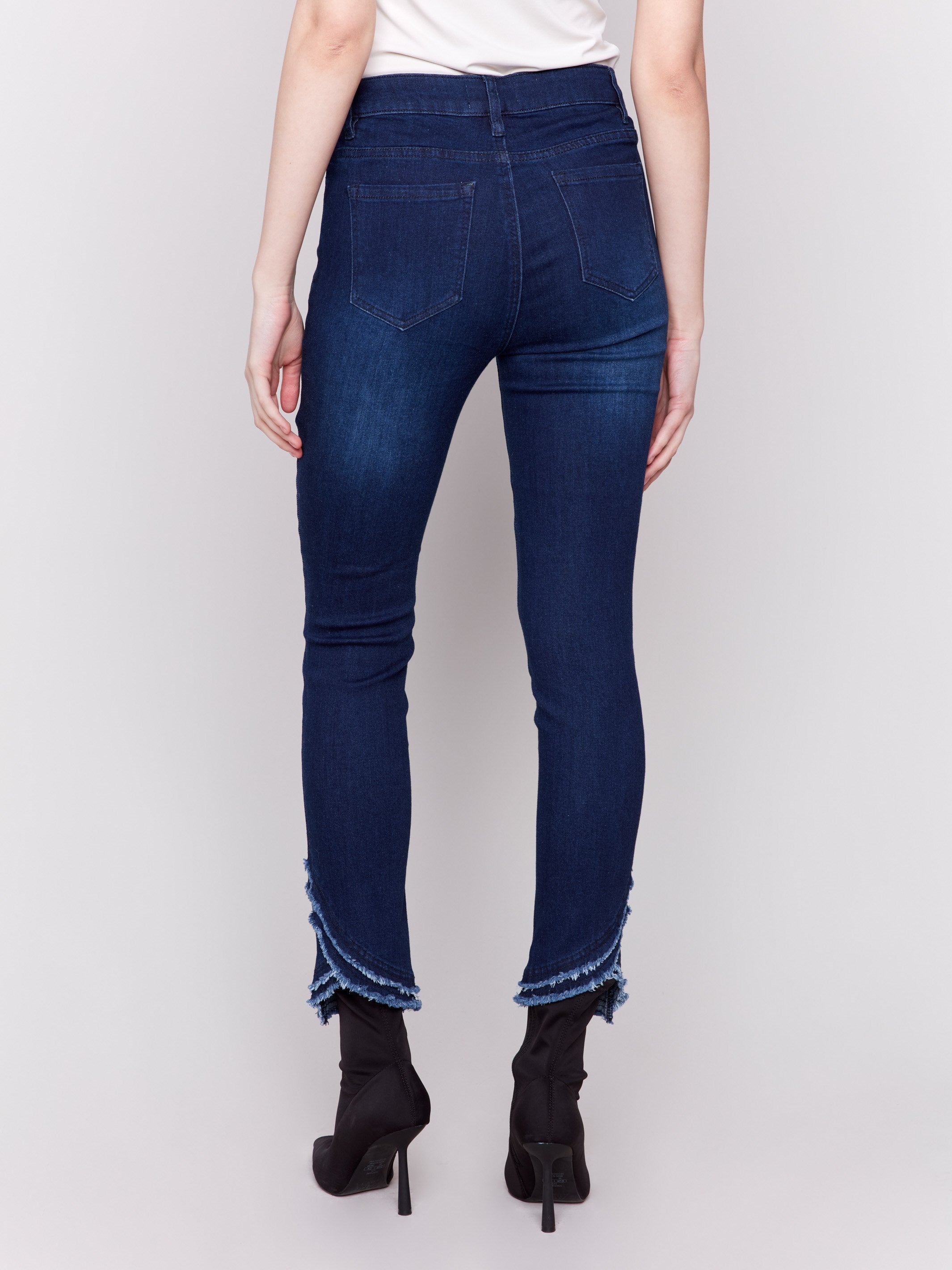 Dark blue slim fit jeans featuring a frayed two-layer tulip hem design, regular rise, and five-pocket style by Charlie B.