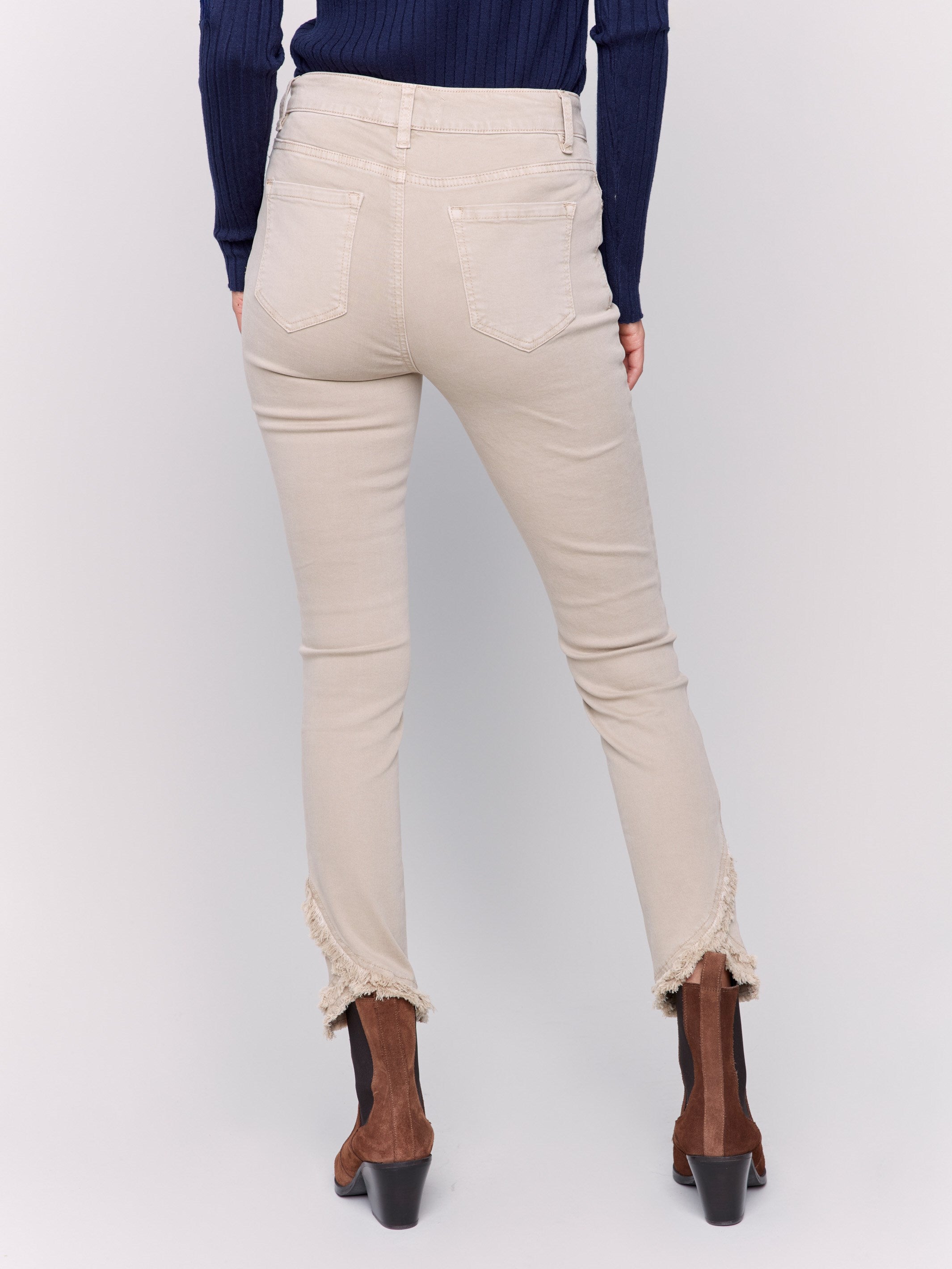 Beige slim fit twill pants with frayed tulip hem, featuring five-pocket design by Charlie B.