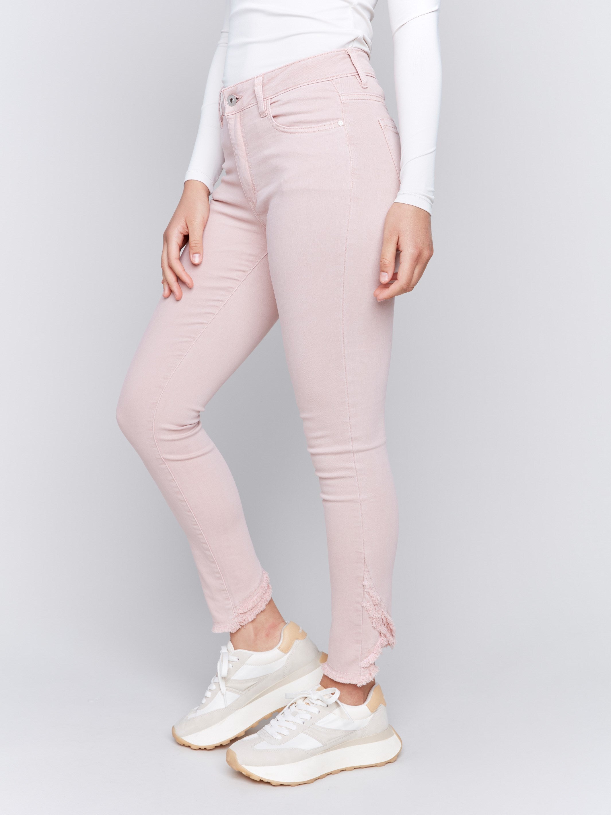 Slim fit twill pants in quartz pink with frayed tulip hem, featuring five-pocket design by Charlie B.