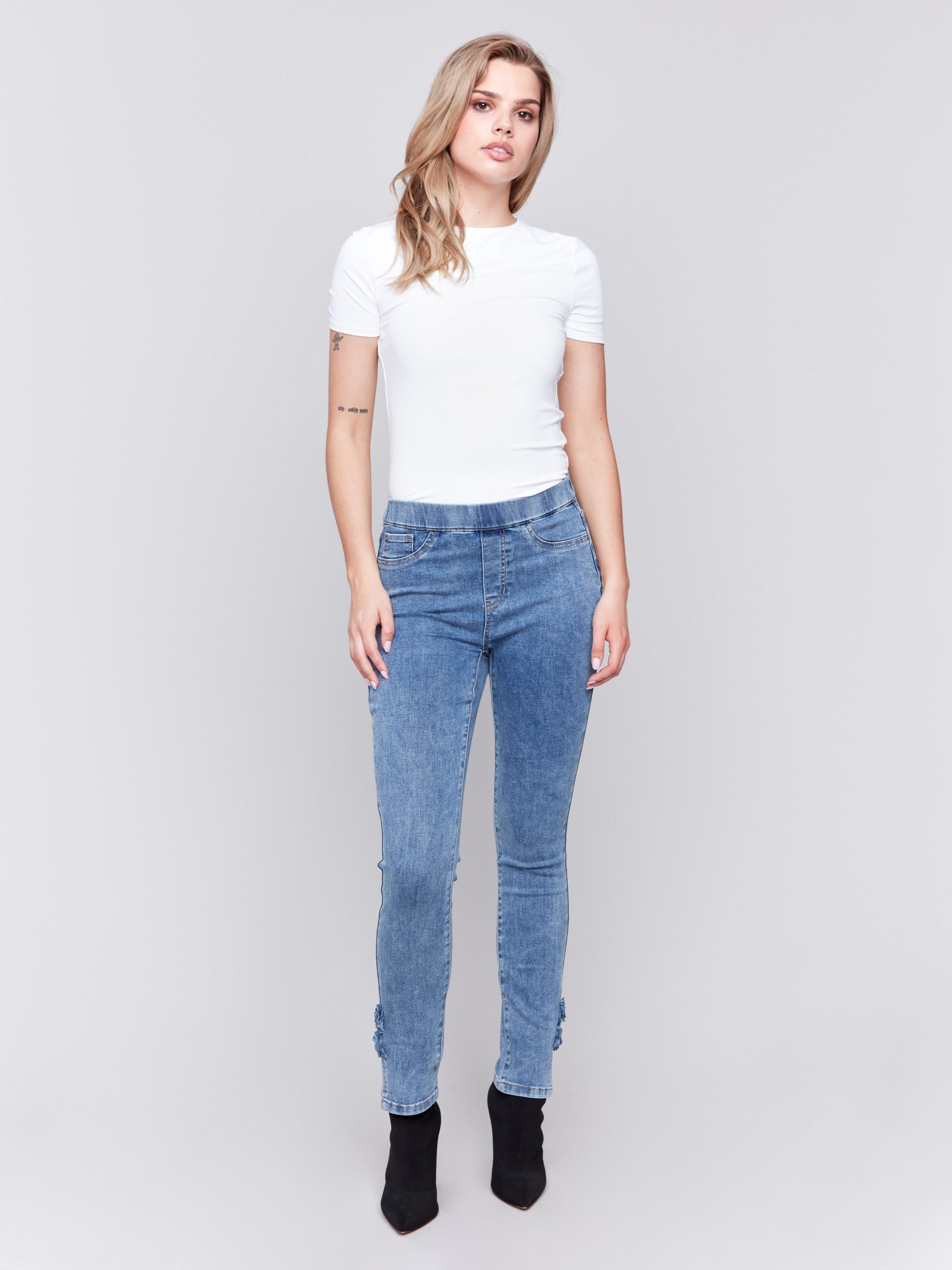 Medium blue jeans with slim leg featuring side rose details and side slits by Charlie B.