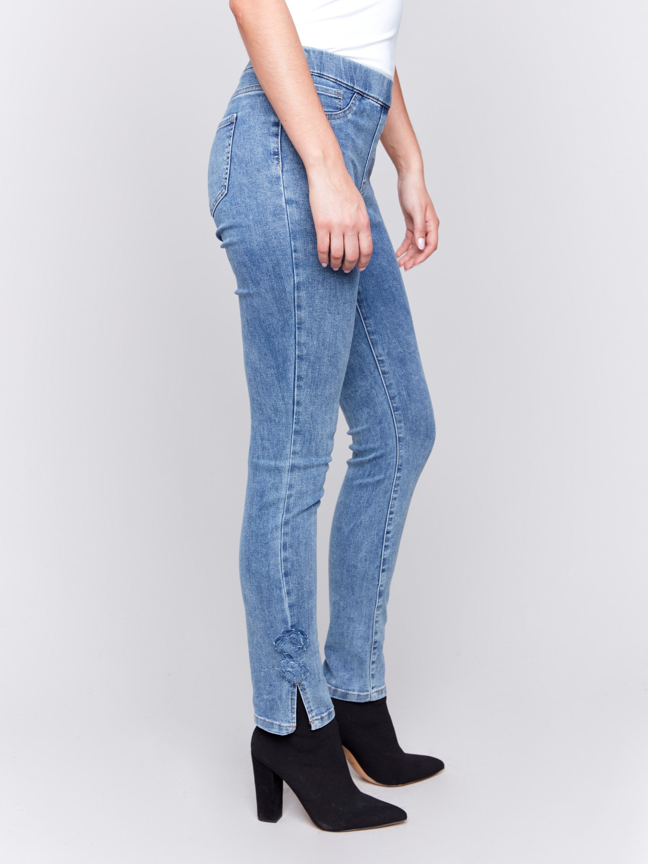 Medium blue jeans with slim leg featuring side rose details and side slits by Charlie B.