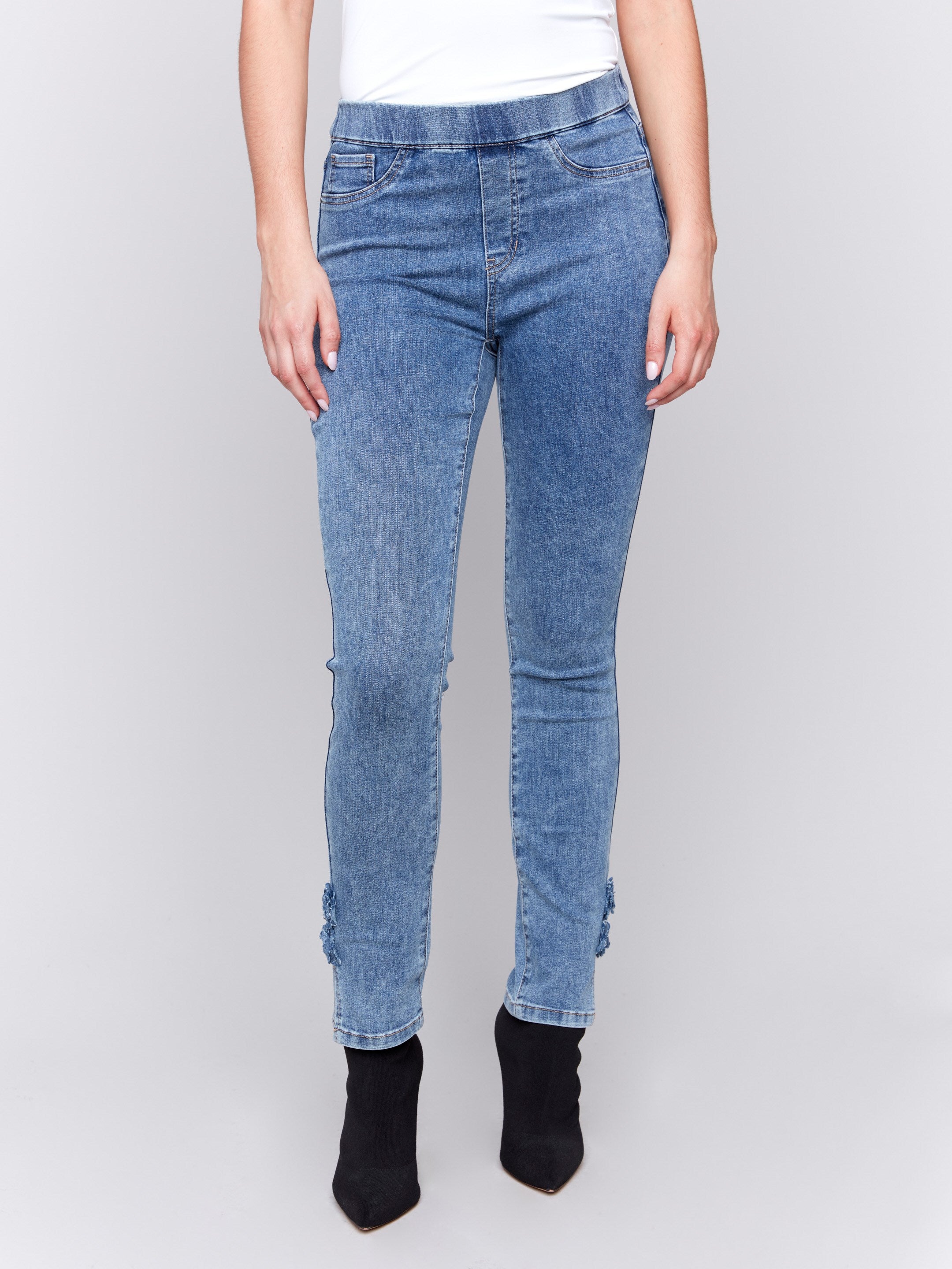 Medium blue jeans with slim leg featuring side rose details and side slits by Charlie B.