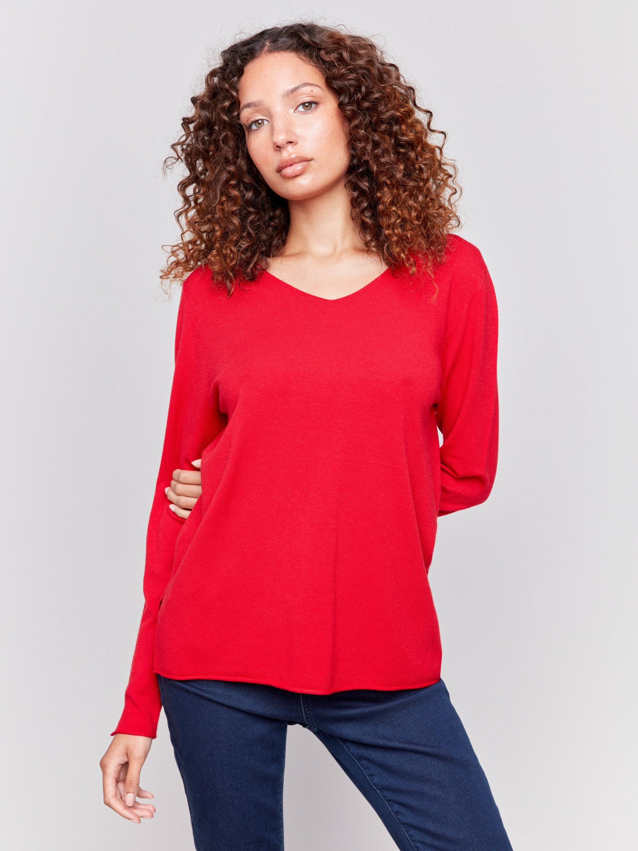 Cranberry red V-neck sweater with long sleeves featuring side slits, made from plushy yarn by Charlie B.