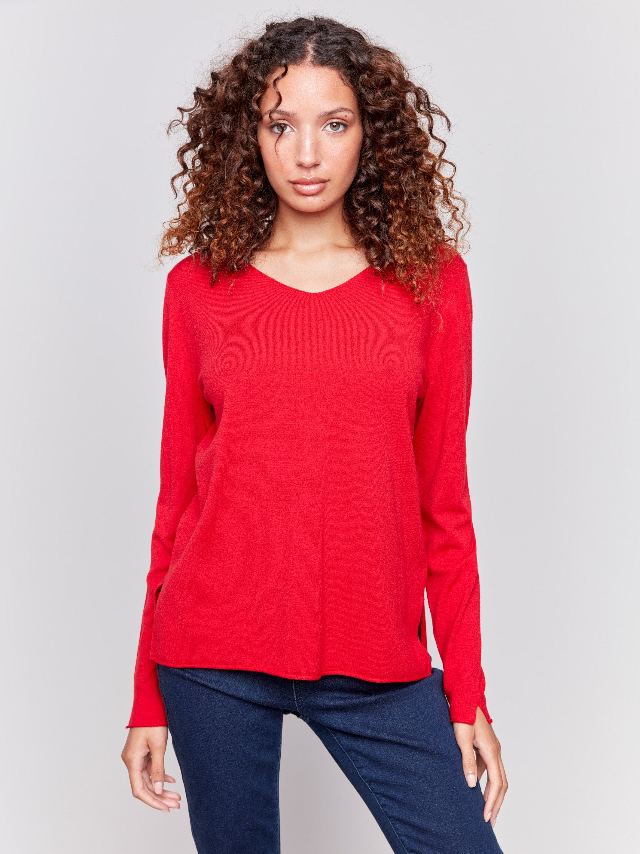 Cranberry red V-neck sweater with long sleeves featuring side slits, made from plushy yarn by Charlie B.