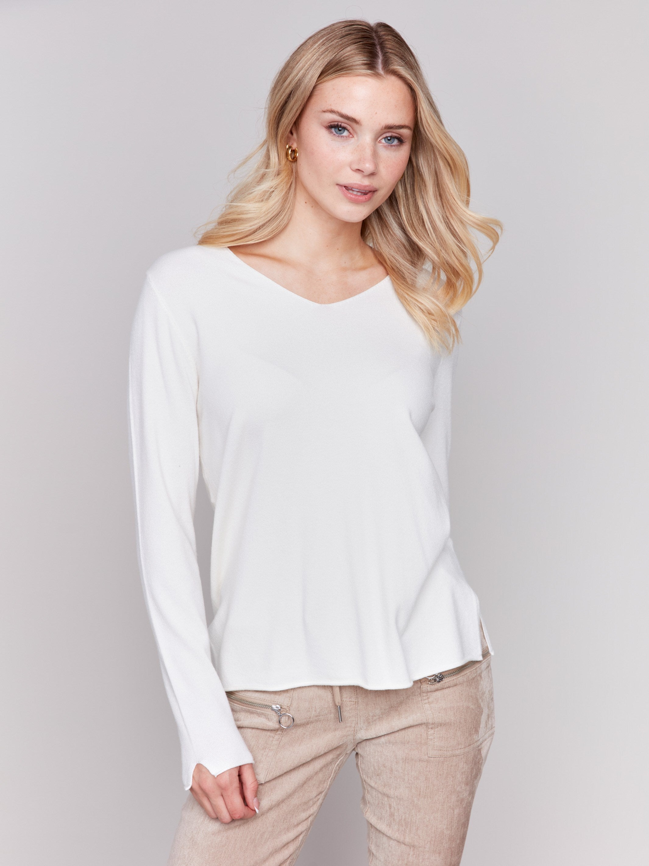 Ecru white V-neck sweater with long sleeves featuring side slits, made from plushy yarn by Charlie B.