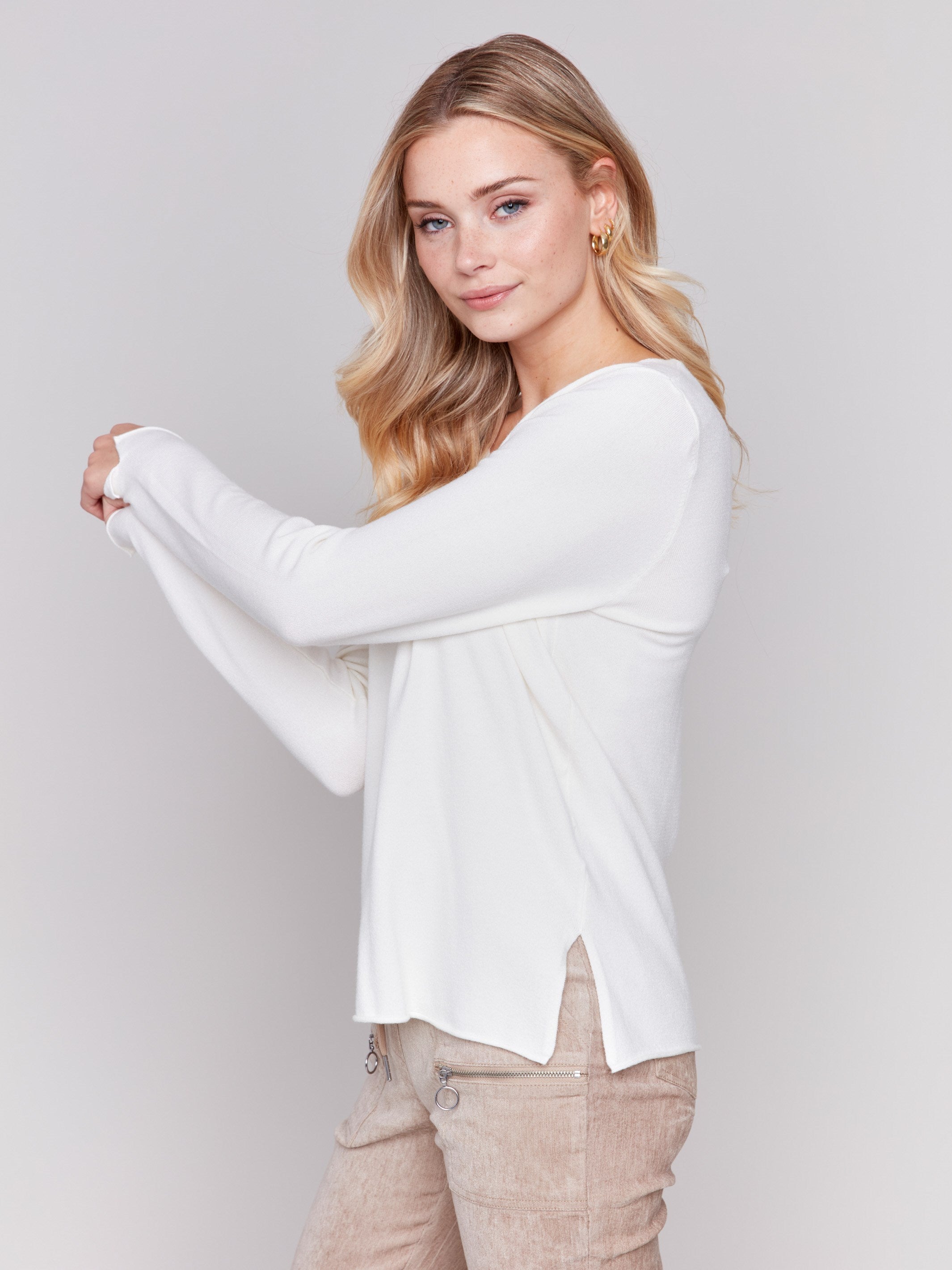 Ecru white V-neck sweater with long sleeves featuring side slits, made from plushy yarn by Charlie B.