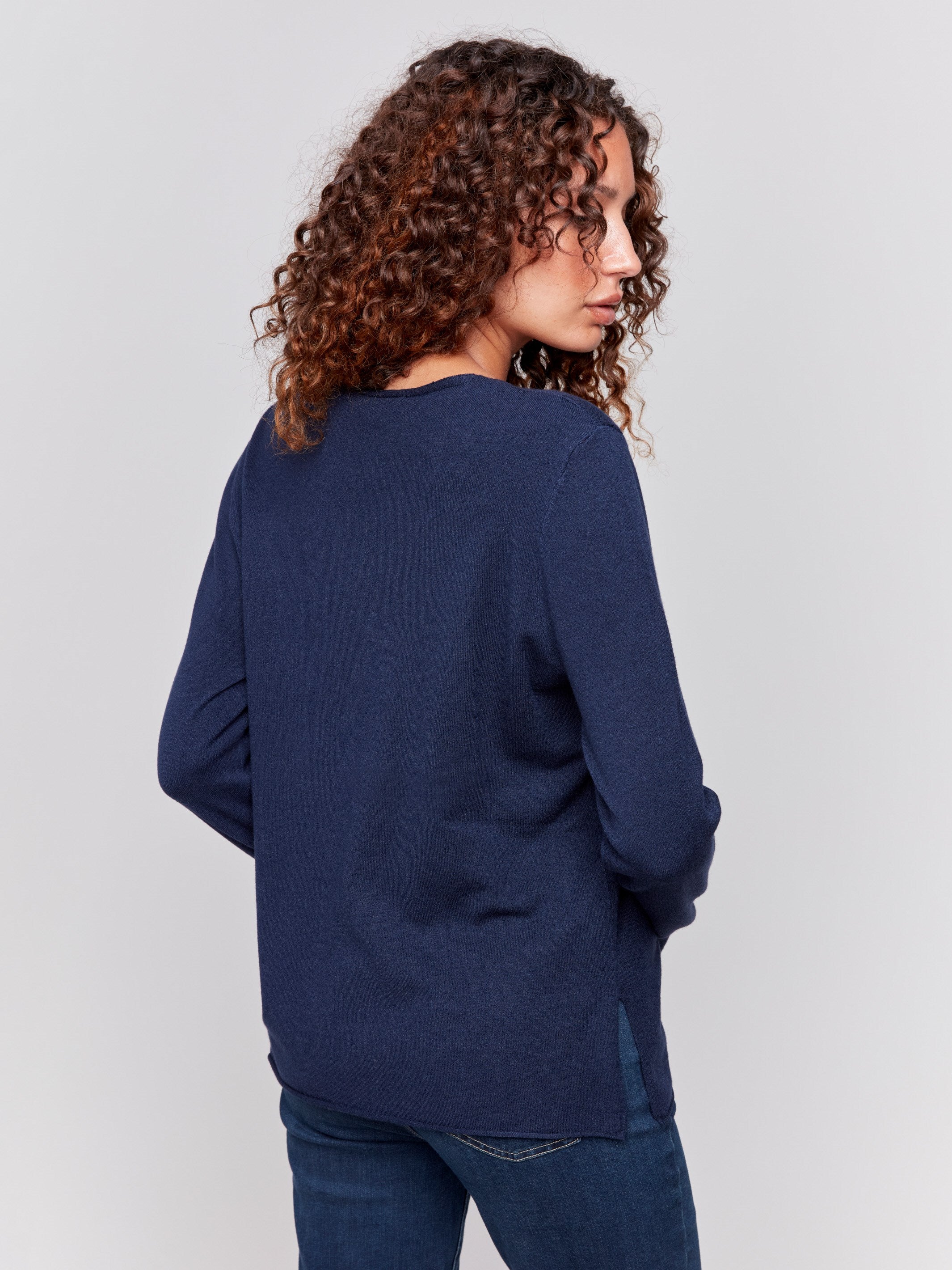 Navy blue V-neck sweater with long sleeves featuring side slits, made from plushy yarn by Charlie B.