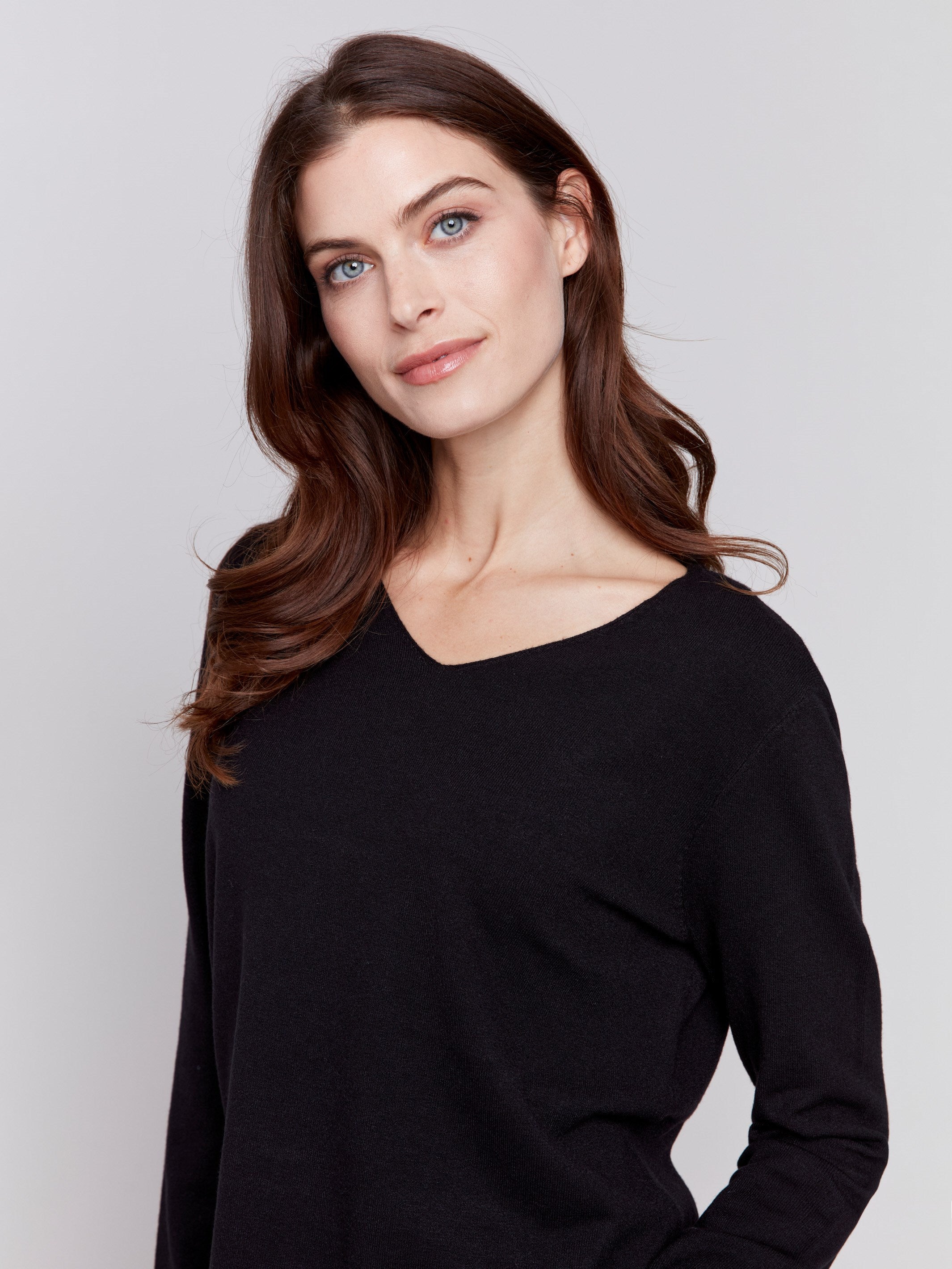 Black V-neck sweater with long sleeves featuring side slits, made from plushy yarn by Charlie B.