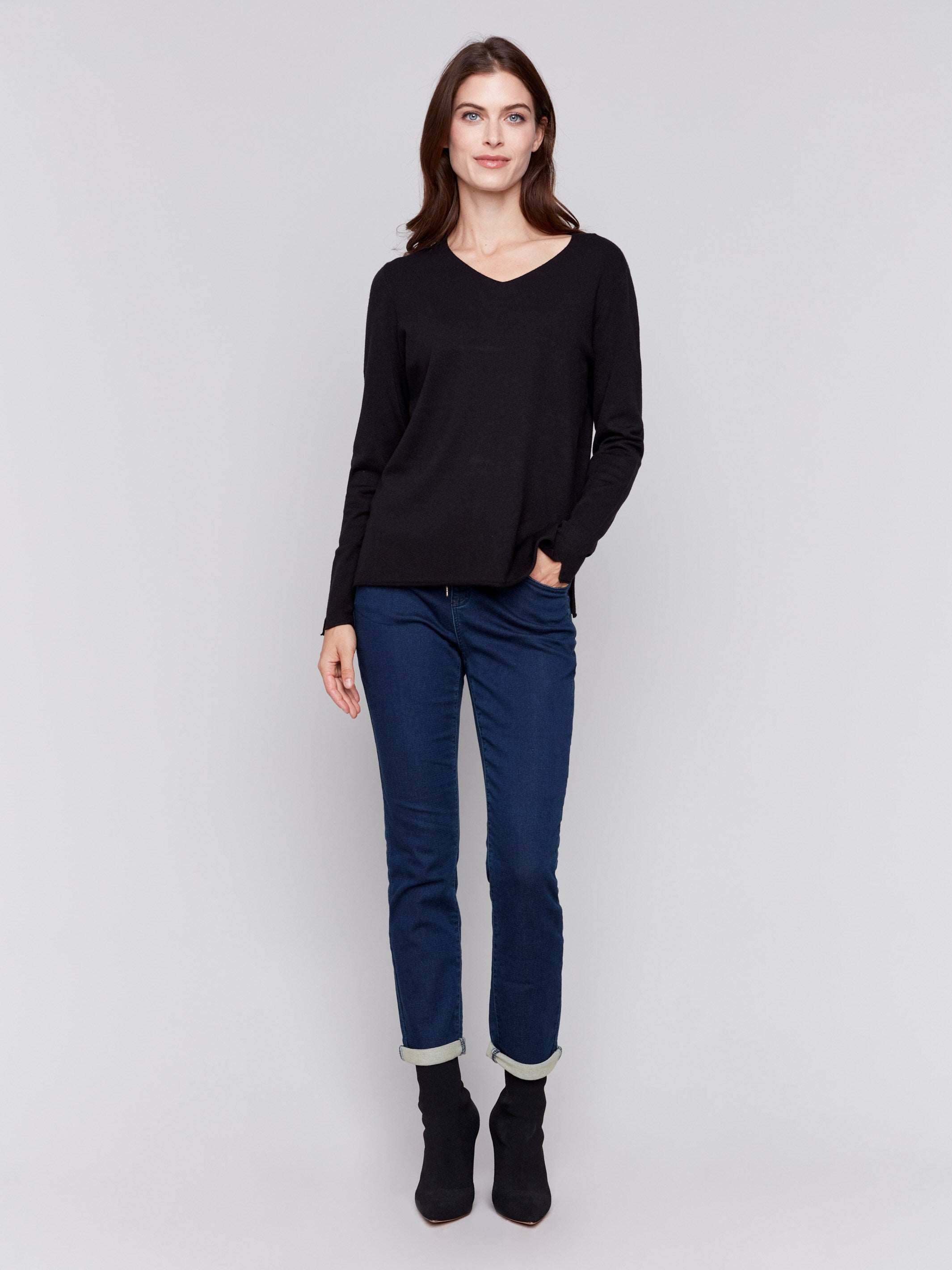 Black V-neck sweater with long sleeves featuring side slits, made from plushy yarn by Charlie B.