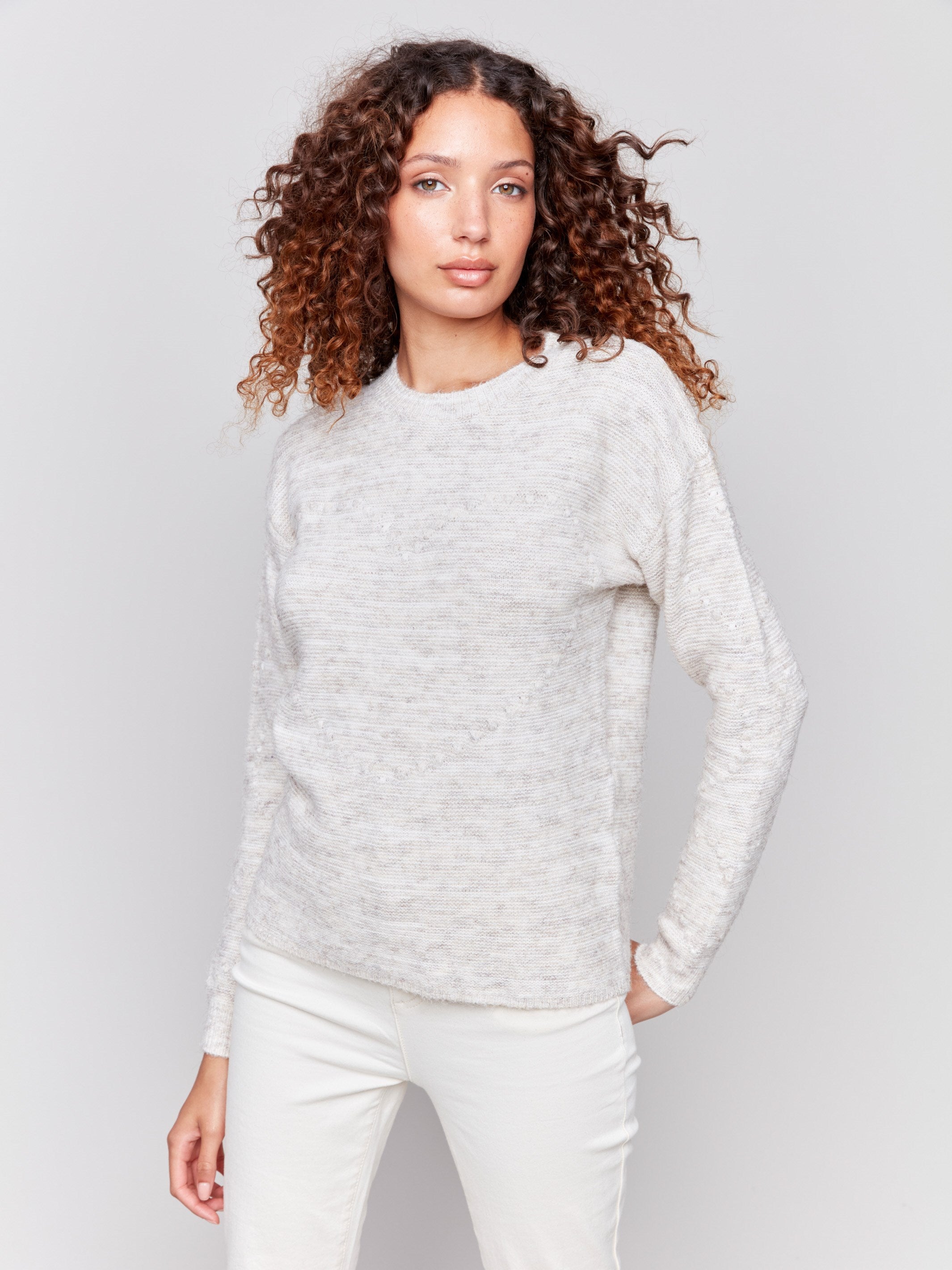 Ecru space dye knit sweater with drop shoulders and a crew neckline by Charlie B.