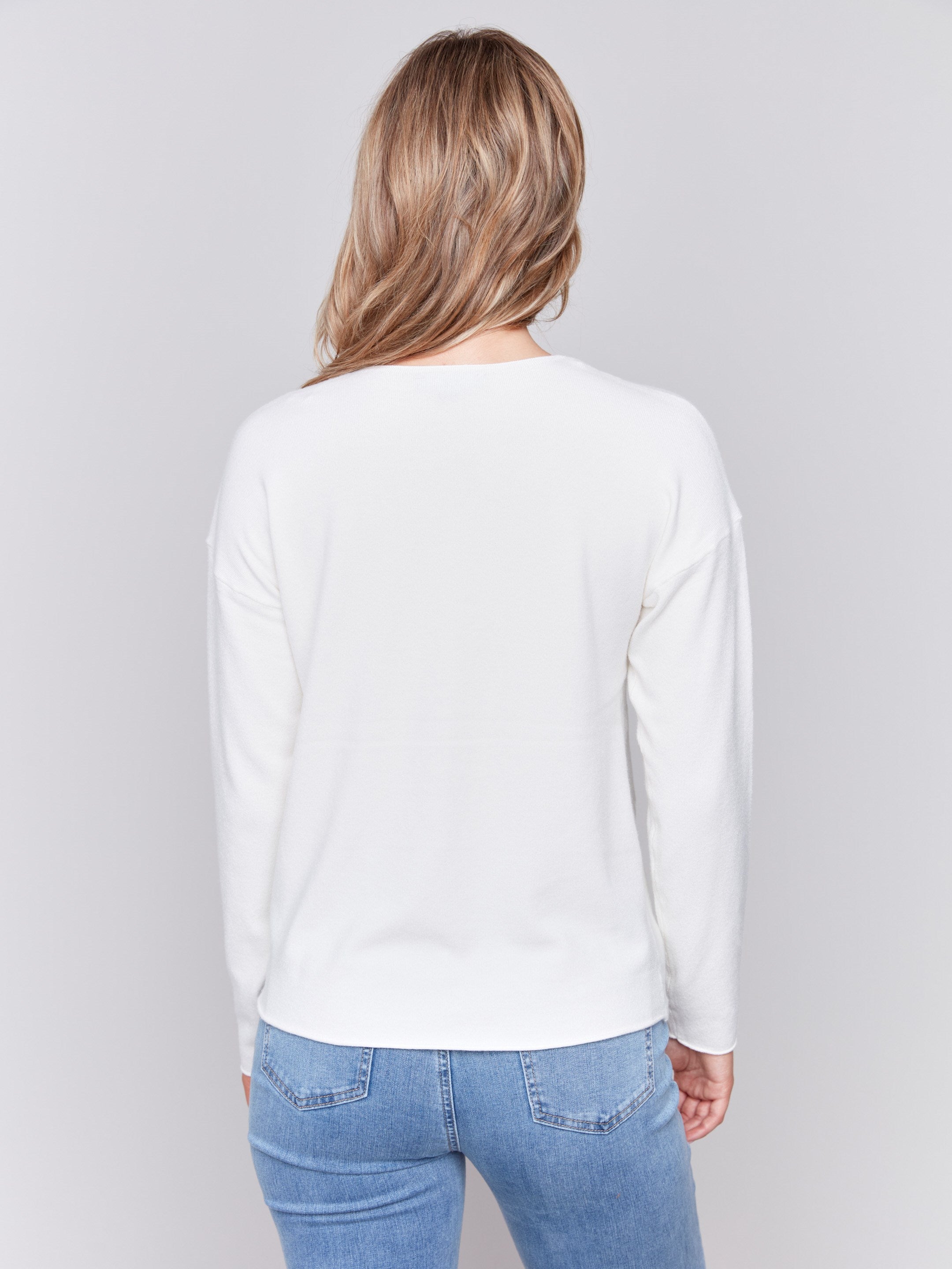 Ecru white long-sleeve sweater with front knot detail and V-neckline by Charlie B.