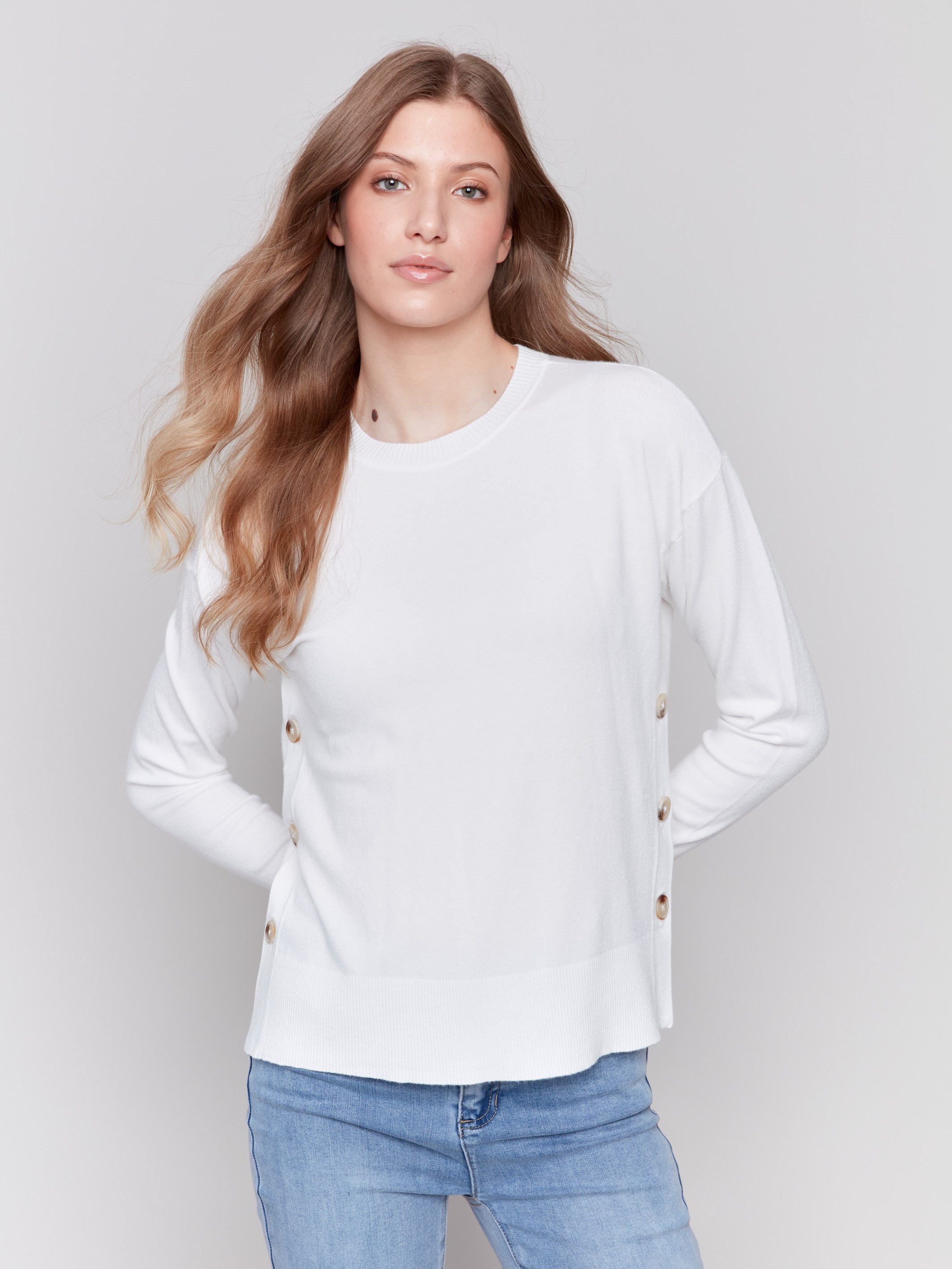 Cream white sweater with long sleeves and side button detailing by Charlie B.