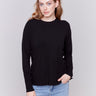 Black sweater with long sleeves and side button detailing by Charlie B.