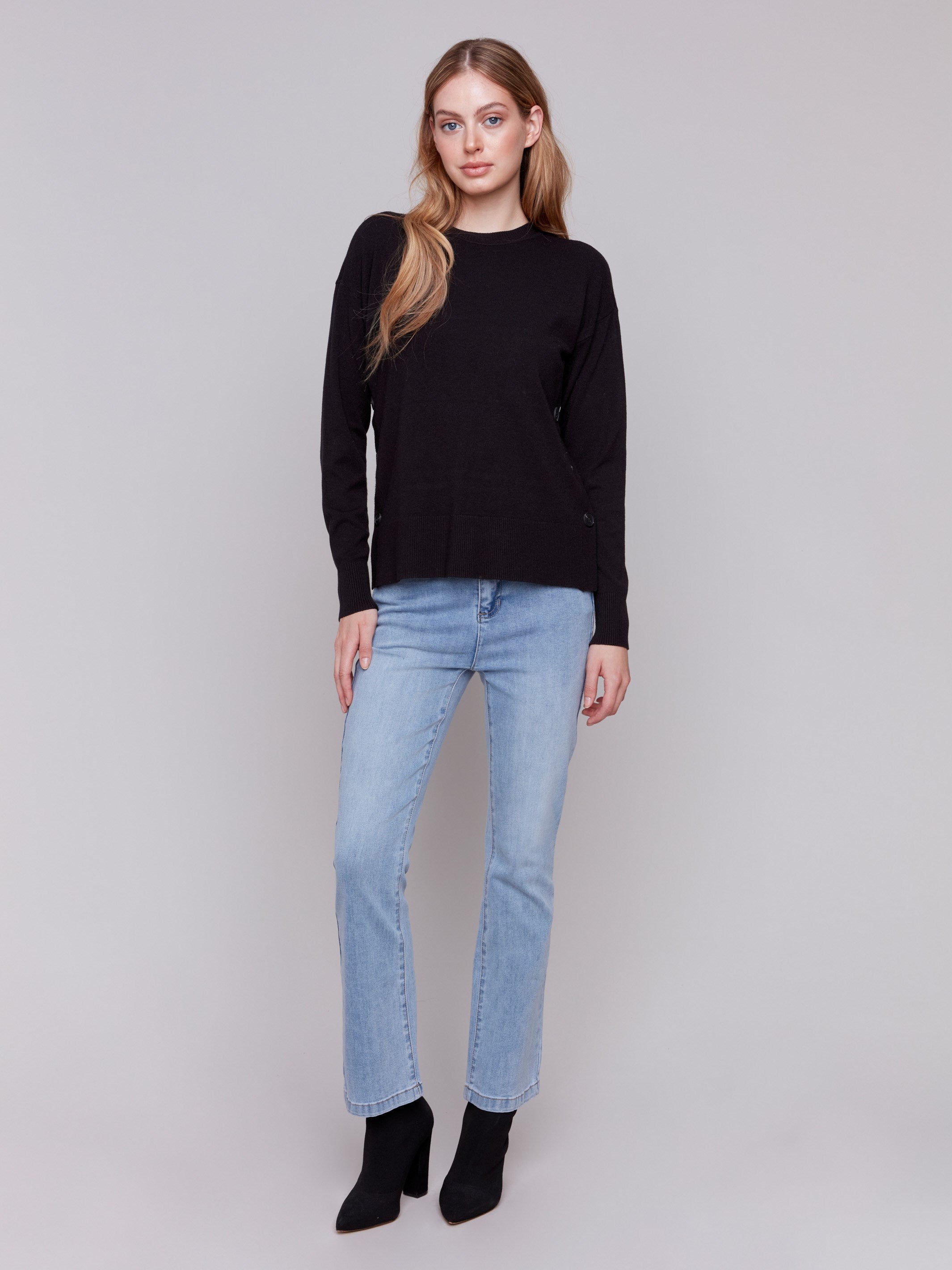 Black sweater with long sleeves and side button detailing by Charlie B.