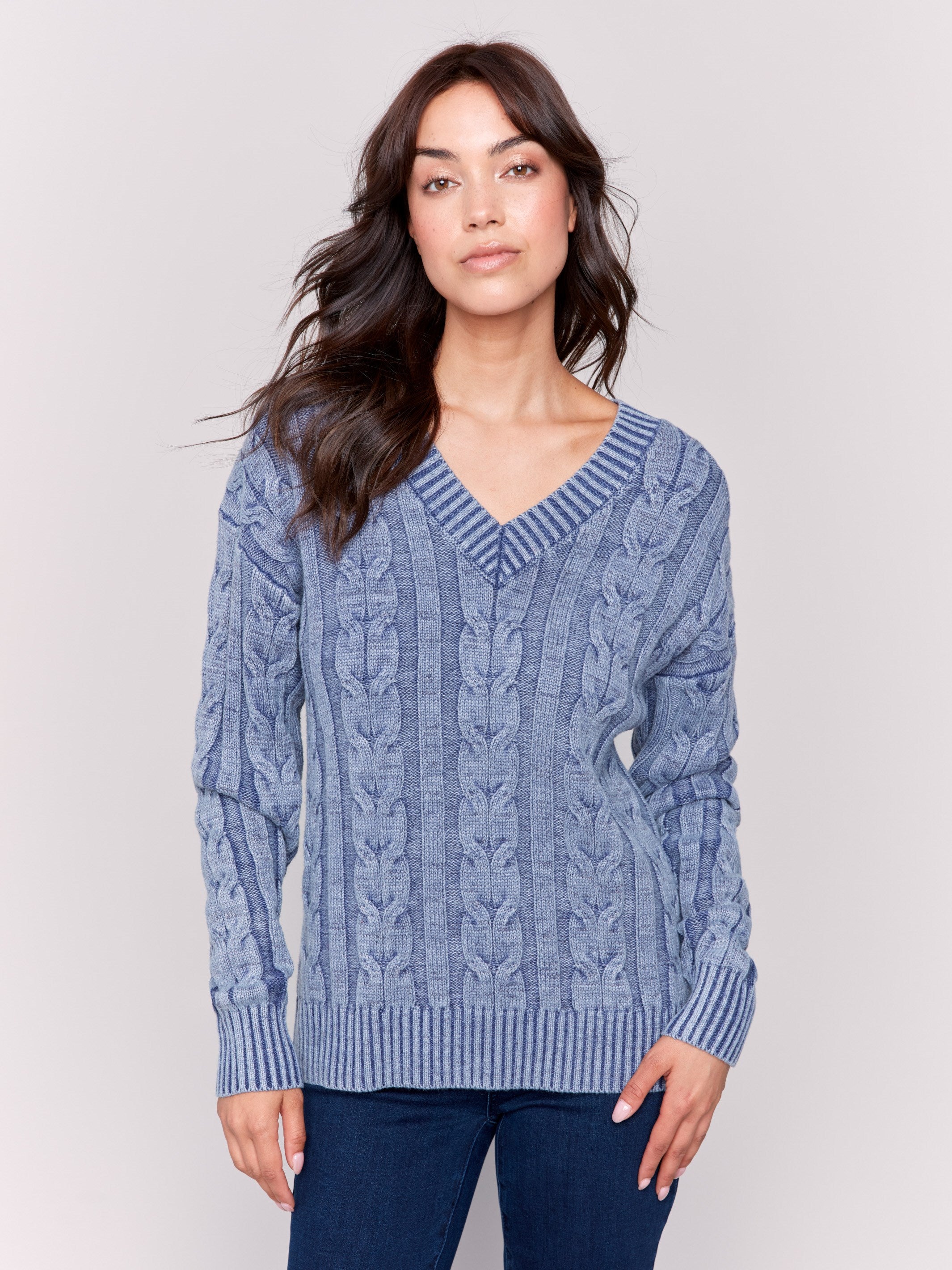 Denim blue cable knit sweater with a V-neckline, long sleeves, and geometric patterns by Charlie B.