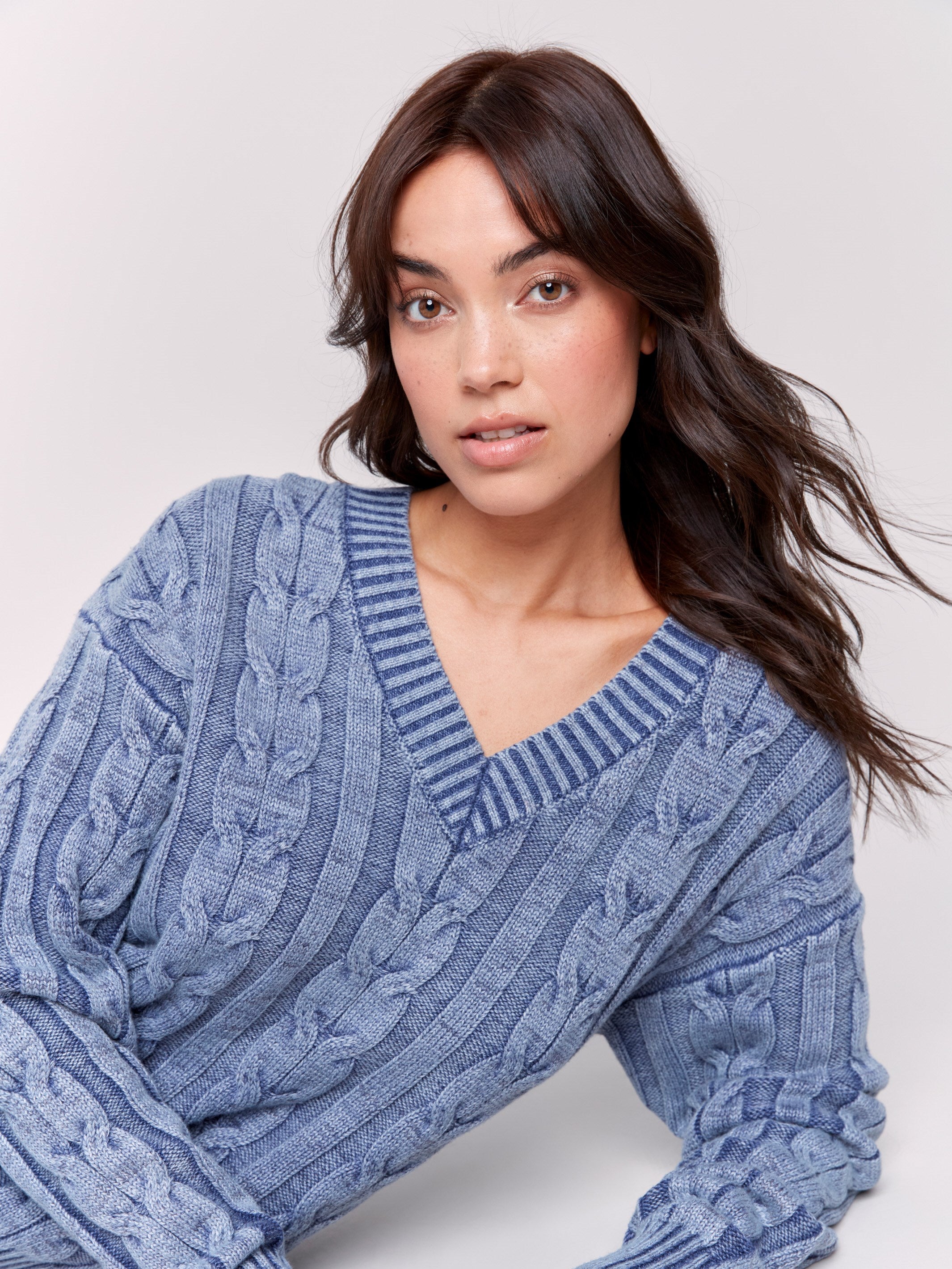 Denim blue cable knit sweater with a V-neckline, long sleeves, and geometric patterns by Charlie B.