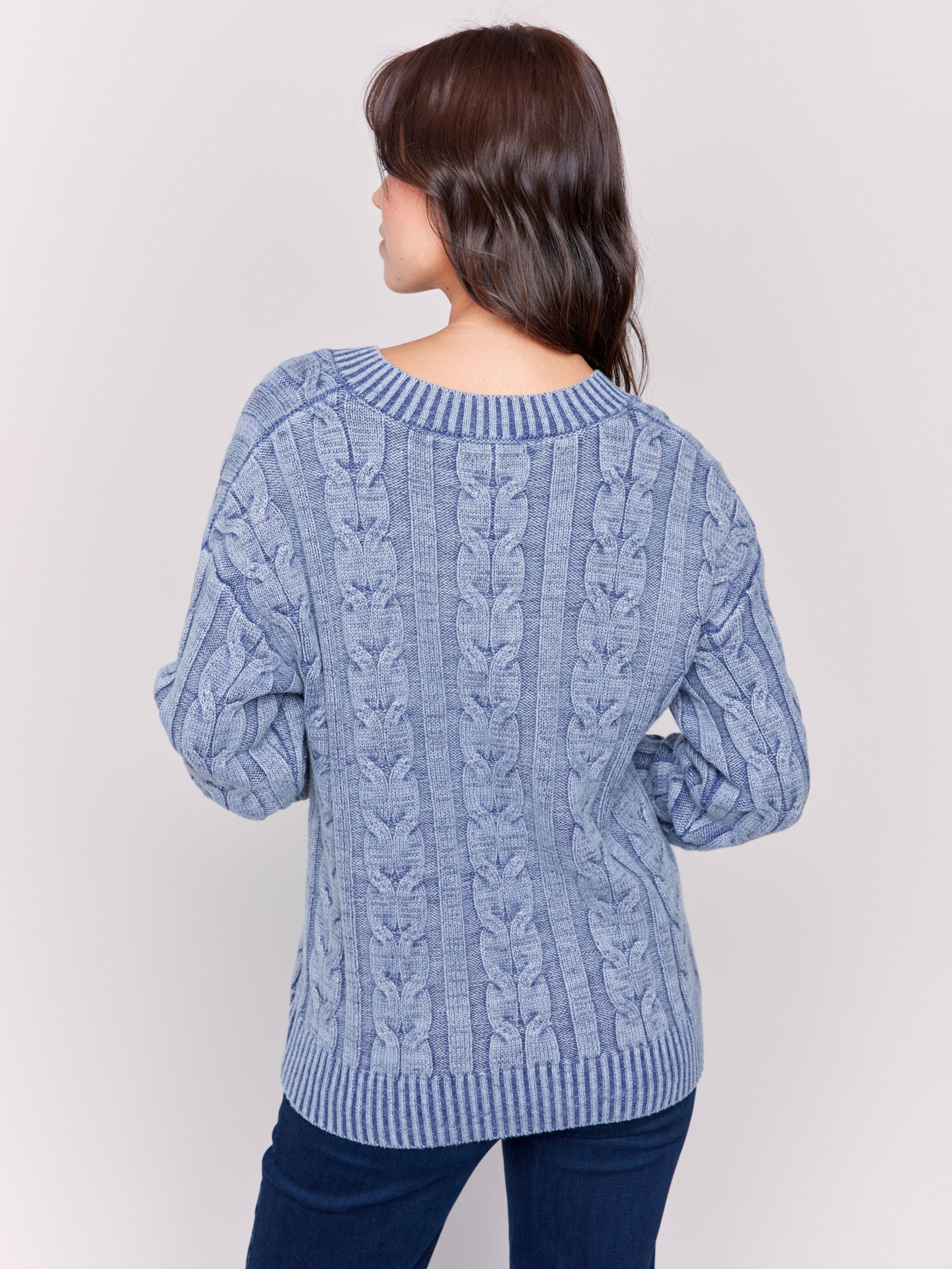 Denim blue cable knit sweater with a V-neckline, long sleeves, and geometric patterns by Charlie B.