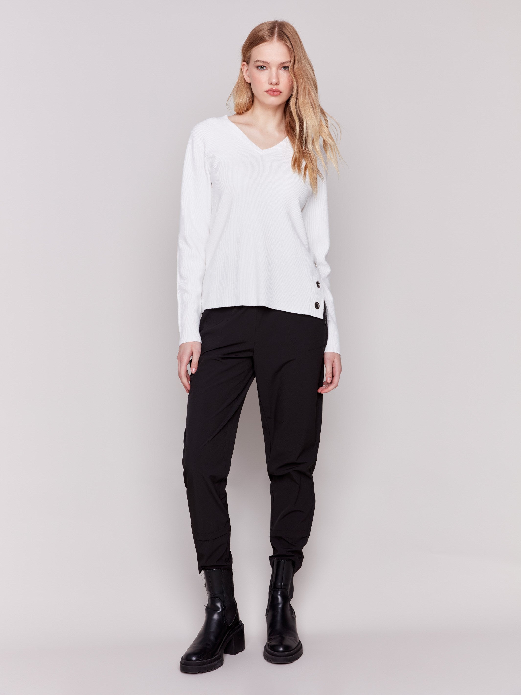 Cream-colored V-neck sweater with long sleeves featuring grommet details at the side placket by Charlie B.