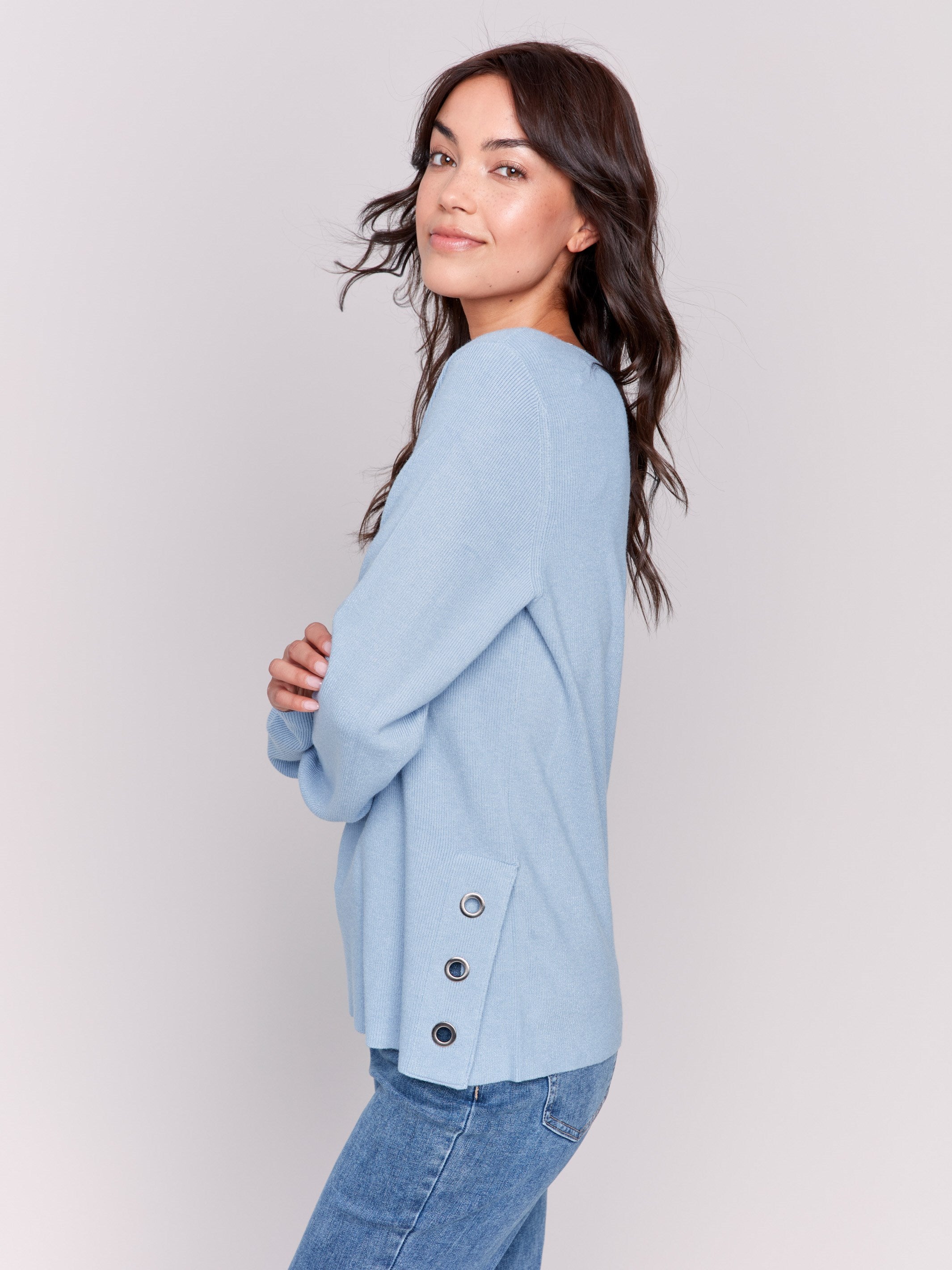 Frost-colored V-neck sweater with long sleeves featuring grommet details at the side placket by Charlie B.